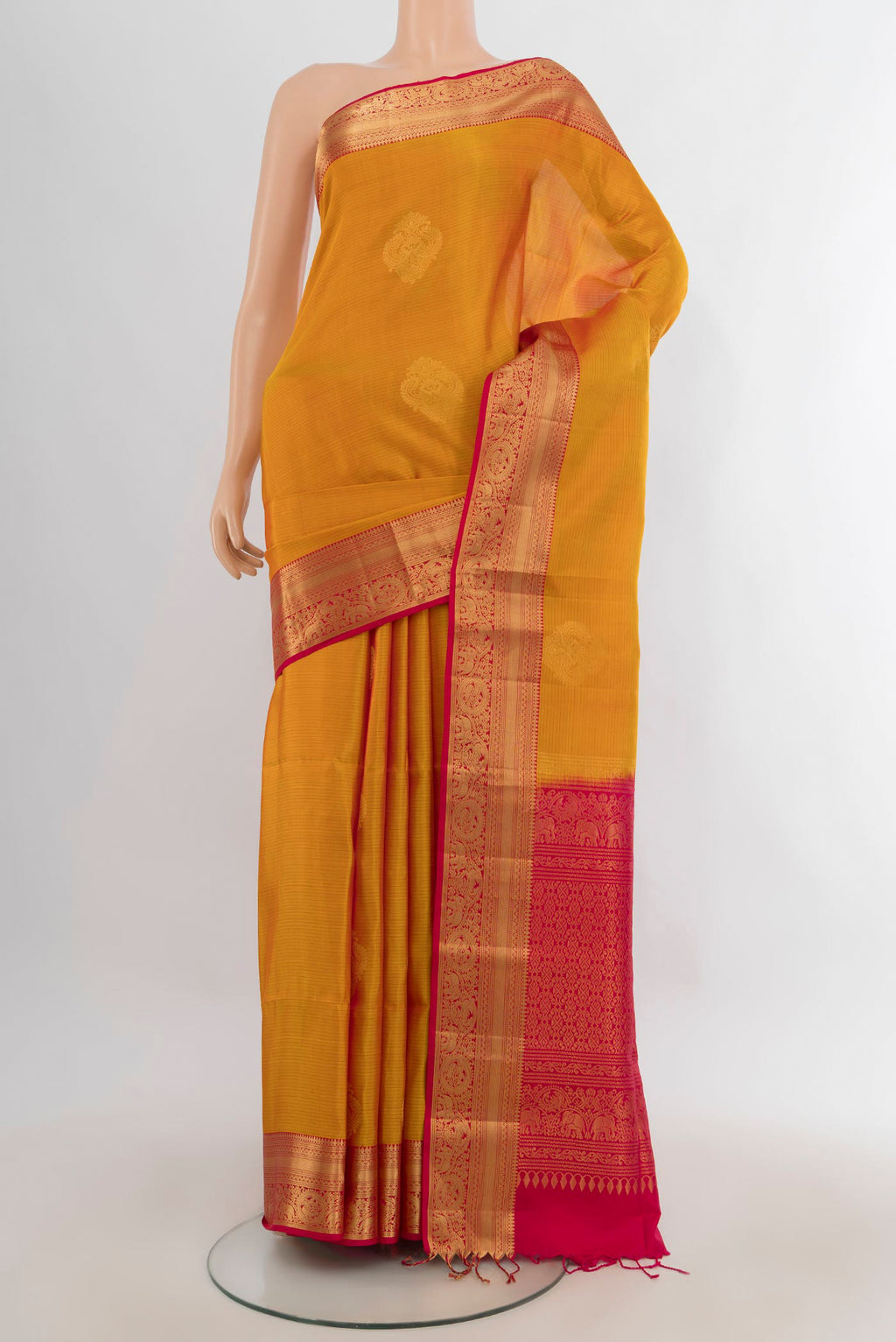 Pure Silk Mustard Soft Saree with Zari Butta on the body and Zari Border.  displayed on a mannequin