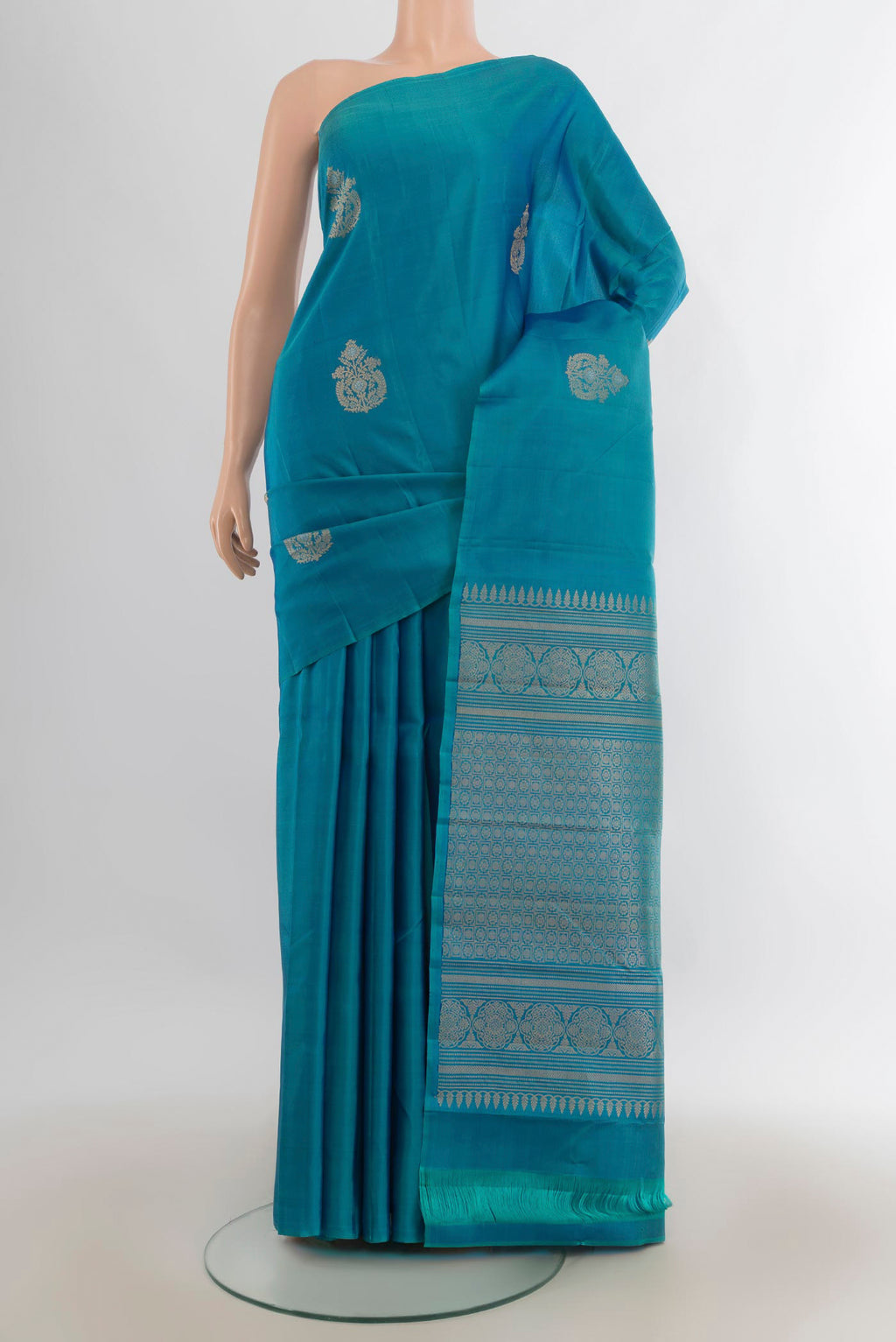 Pure Silk Peacock Blue Soft Saree with Zari Butta on the body and Without Border.  displayed on a mannequin