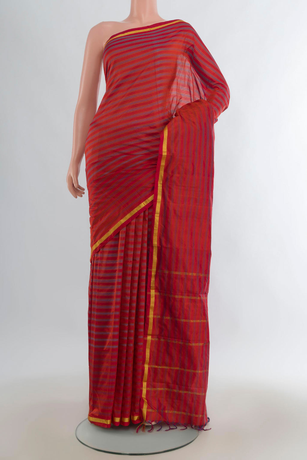 Pure Silk Brick Orange Kanchipuram Saree with Stripes on the body and Zari Border.  displayed on a mannequin