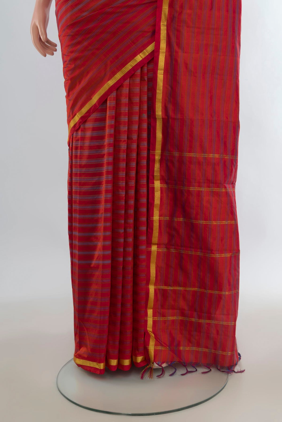 Pleats and pallu of Pure Silk Brick Orange Kanchipuram Saree with Stripes on the body and Zari Border. 