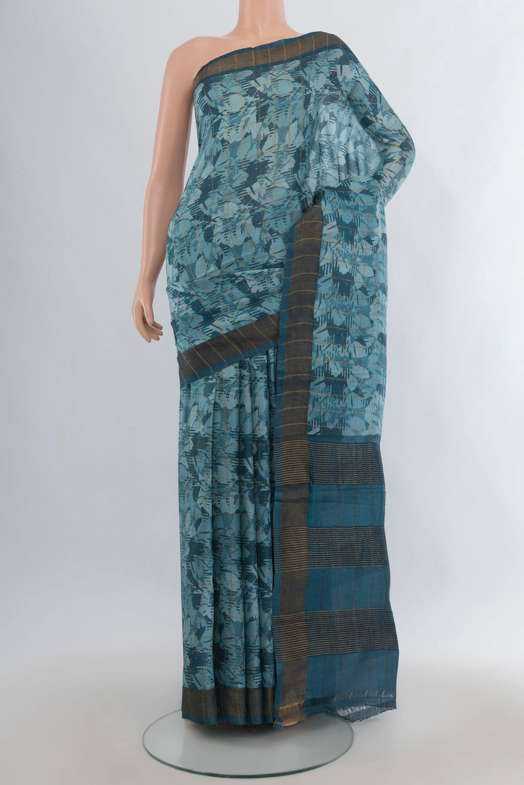 Teal Tussar Saree with Floral Print on the body and Zari Border.  displayed on a mannequin