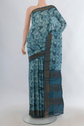 Teal Tussar Saree with Floral Print on the body and Zari Border.  displayed on a mannequin