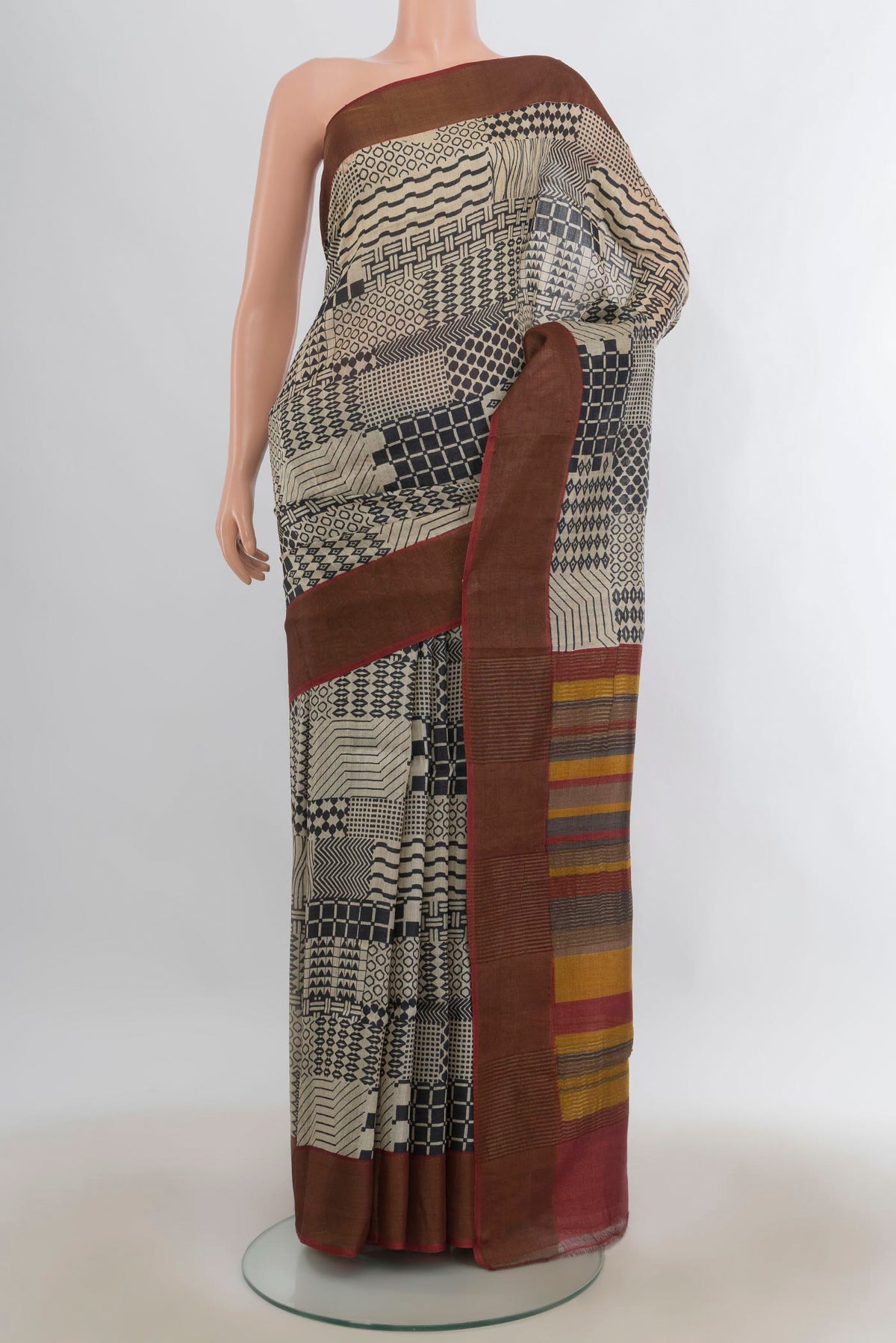 Beige Tussar Saree with Printed design on the body and Zari Border.  displayed on a mannequin