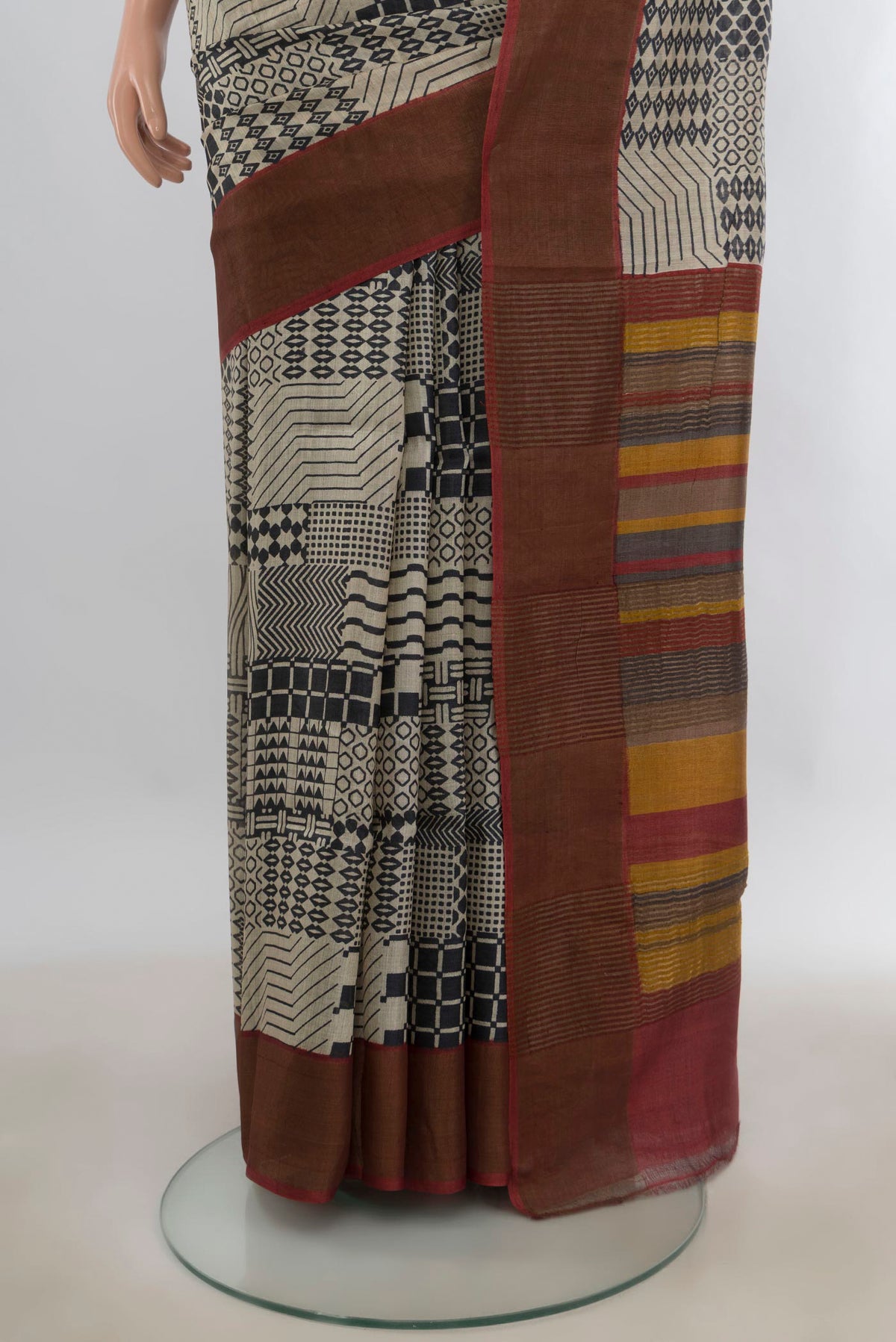 Pleats and pallu of Beige Tussar Saree with Printed design on the body and Zari Border. 