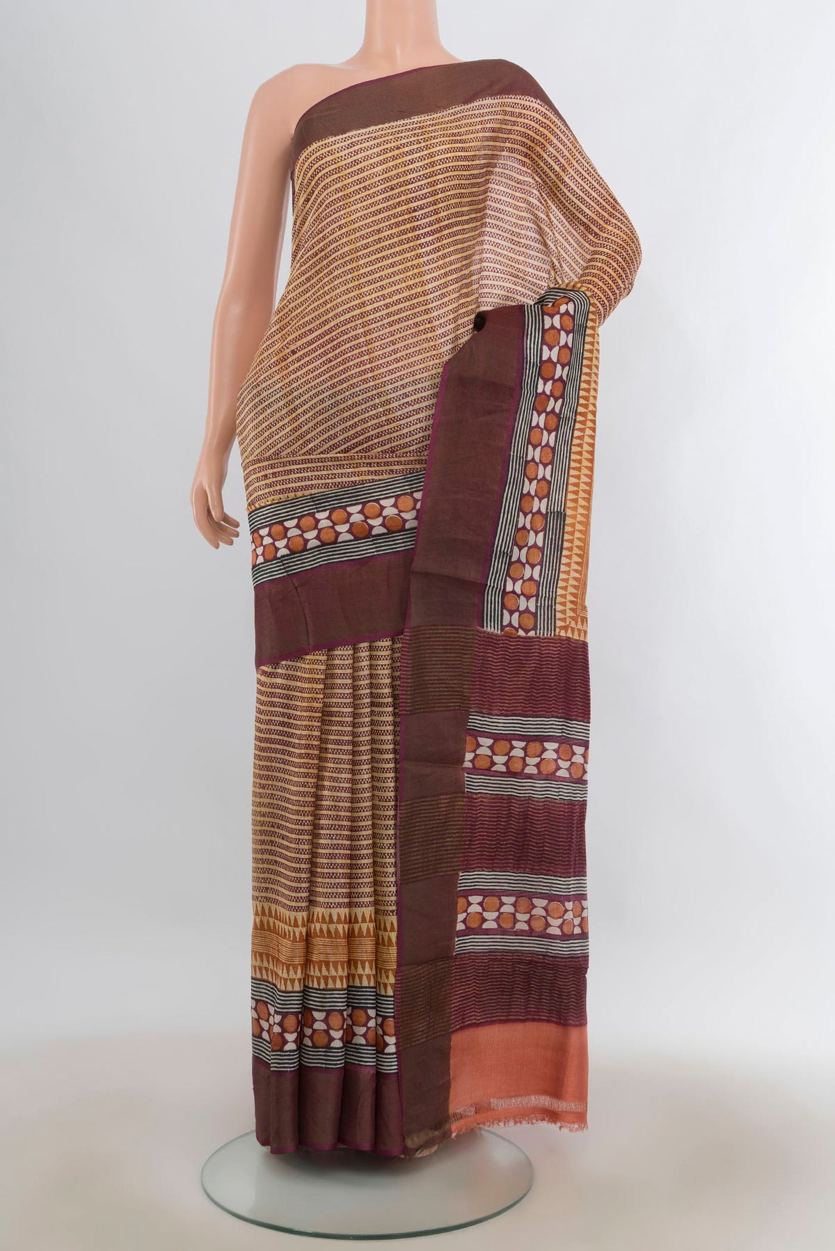 Beige Tussar Saree with Printed design on the body and Zari Border.  displayed on a mannequin