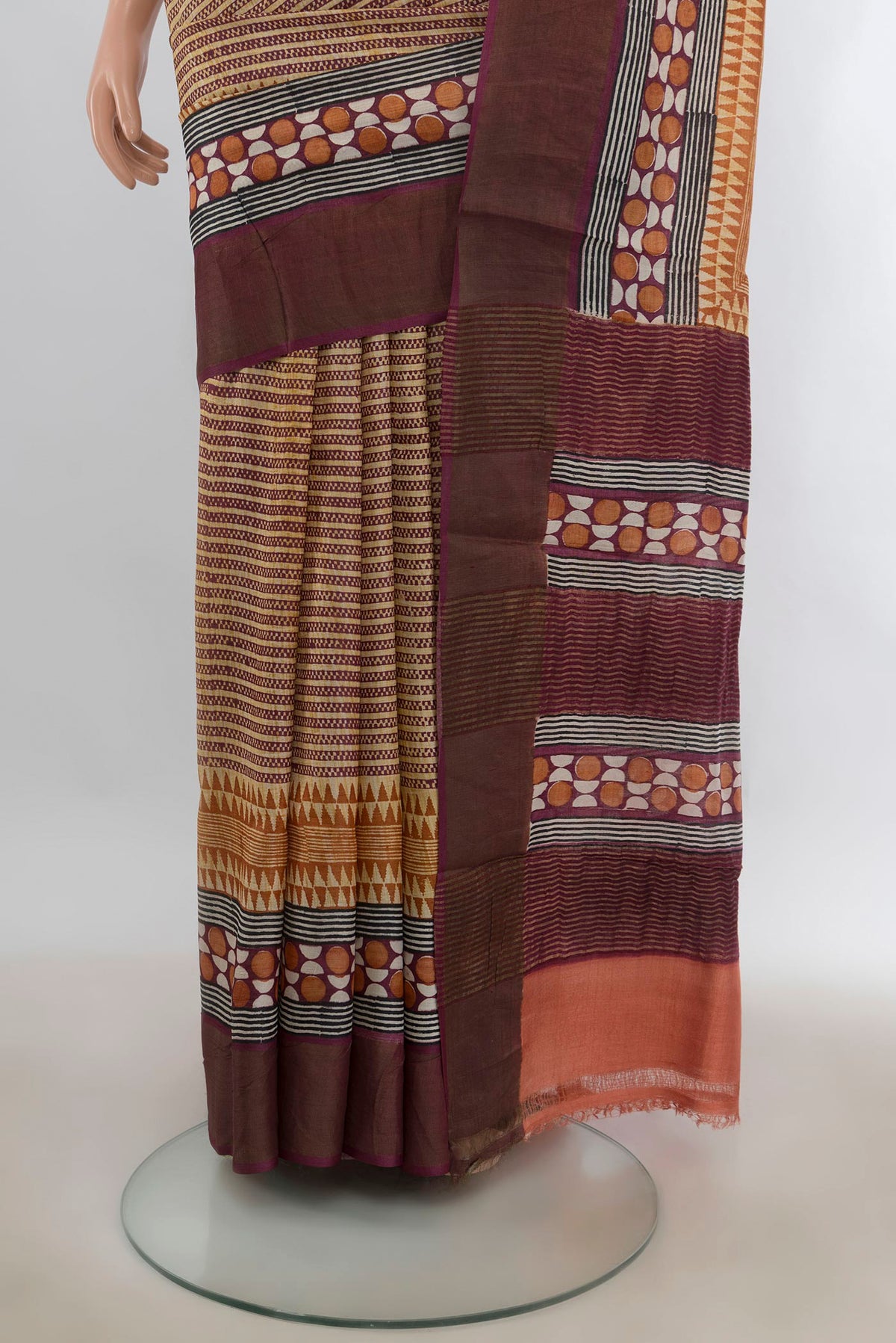 Pleats and pallu of Beige Tussar Saree with Printed design on the body and Zari Border. 