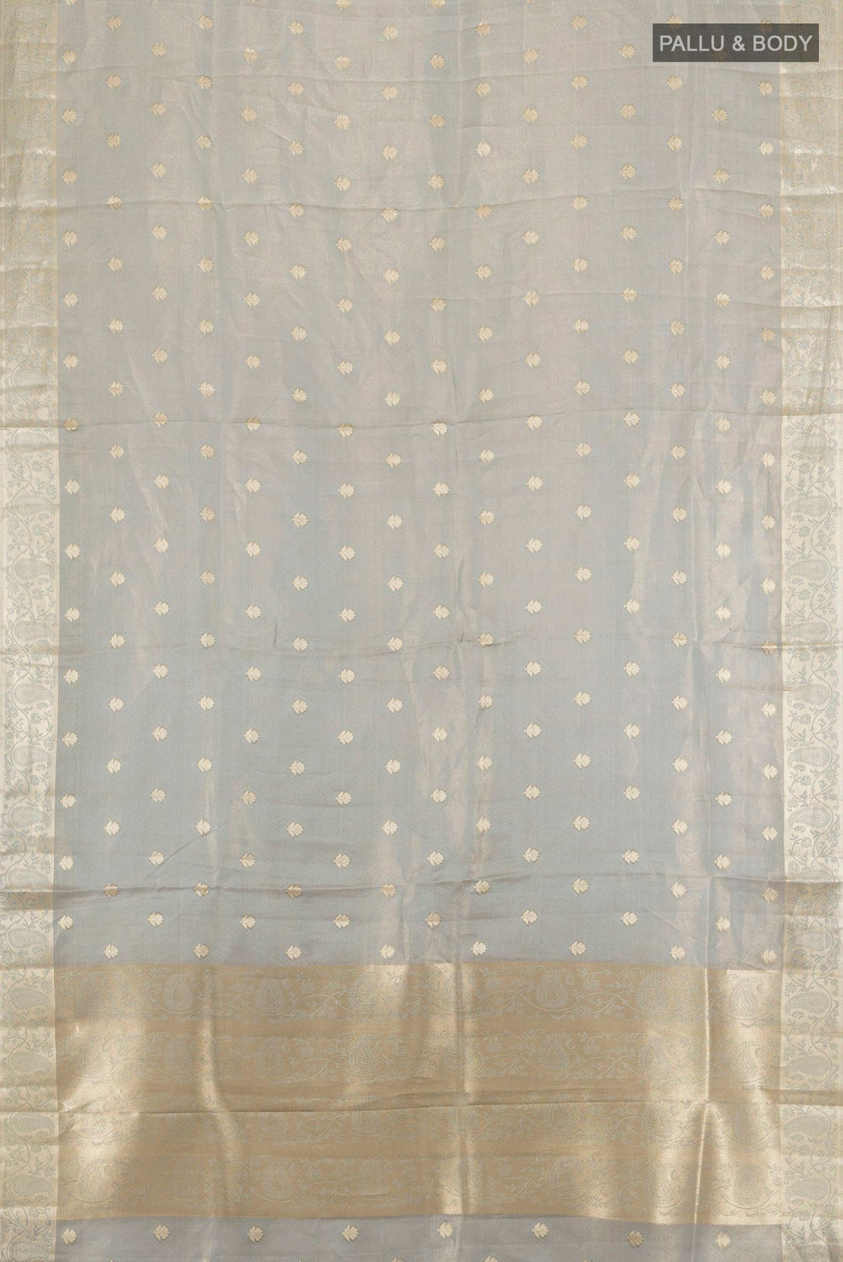 Flat view of Grey Tissue Saree with Zari Butta on the body and Zari Border. 