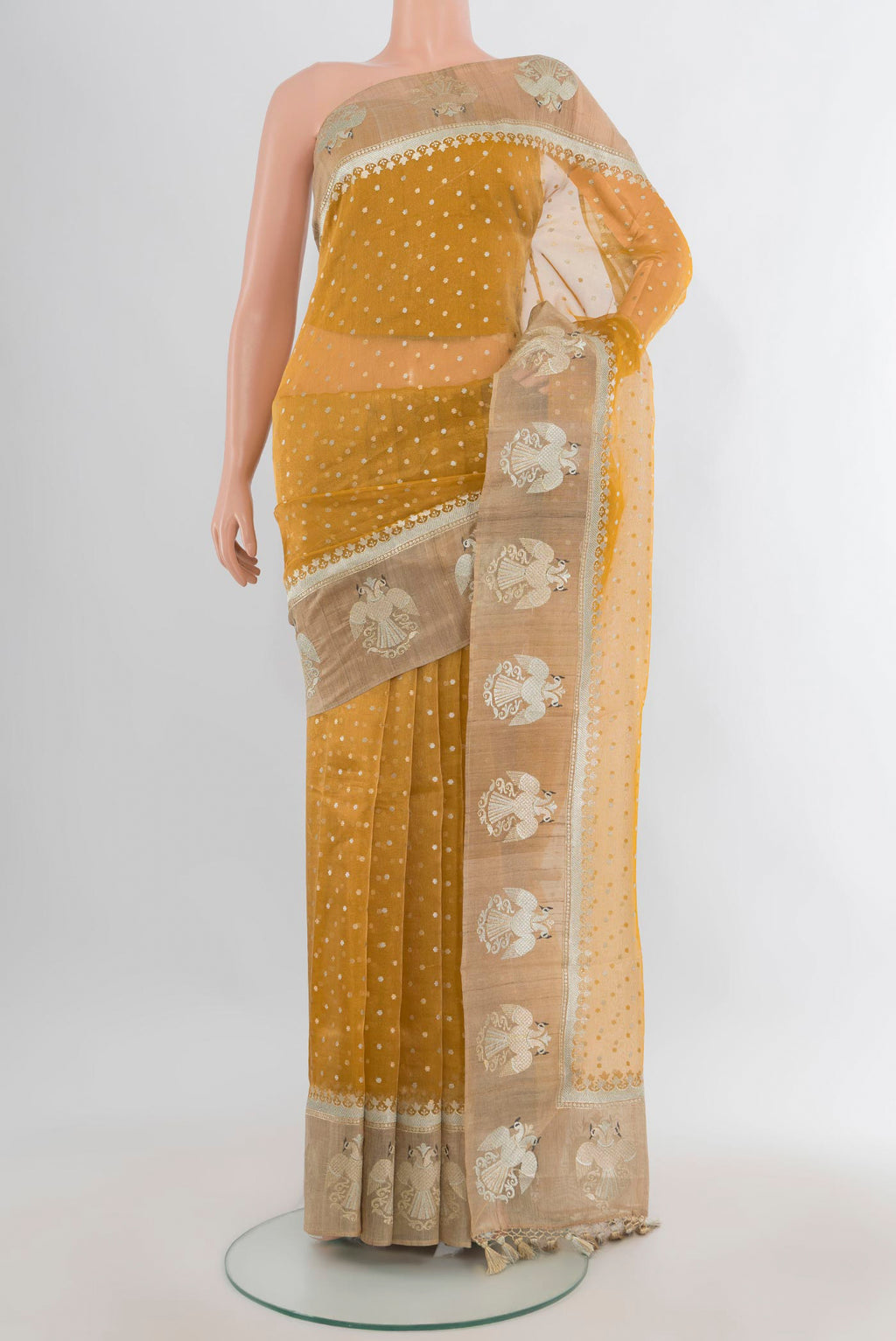 Golden Tussar Saree with Zari Butta on the body and Zari Border.  displayed on a mannequin