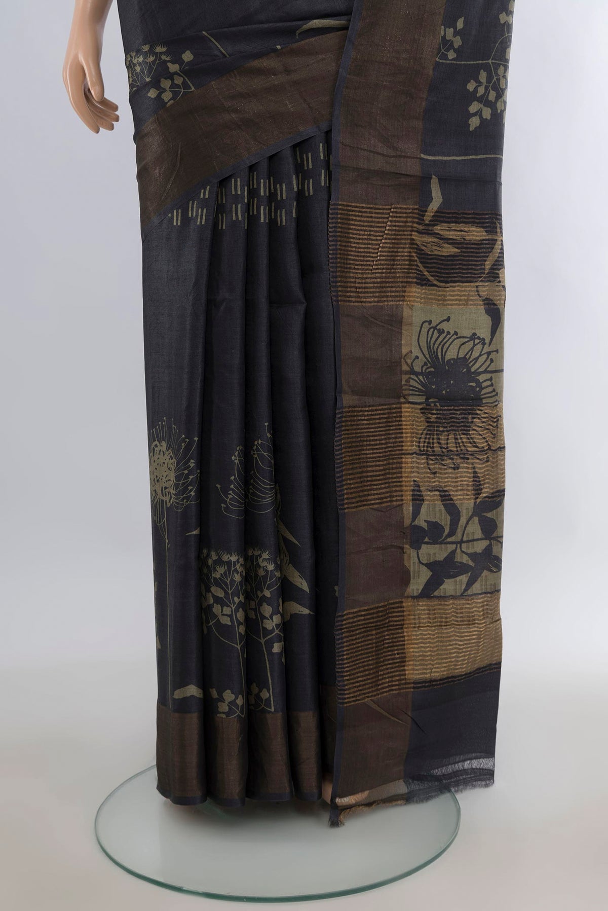 Pleats and pallu of Black Tussar Saree with Printed design on the body and Zari Border. 