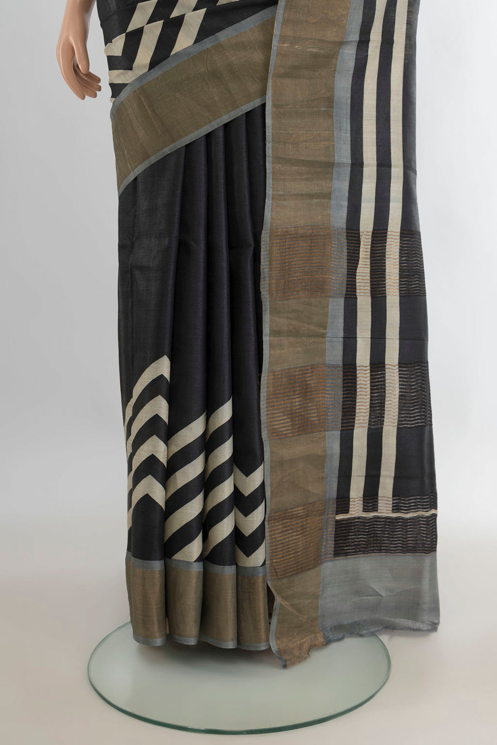 Pleats and pallu of Black Tussar Saree with Floral Print on the body and Zari Border. 