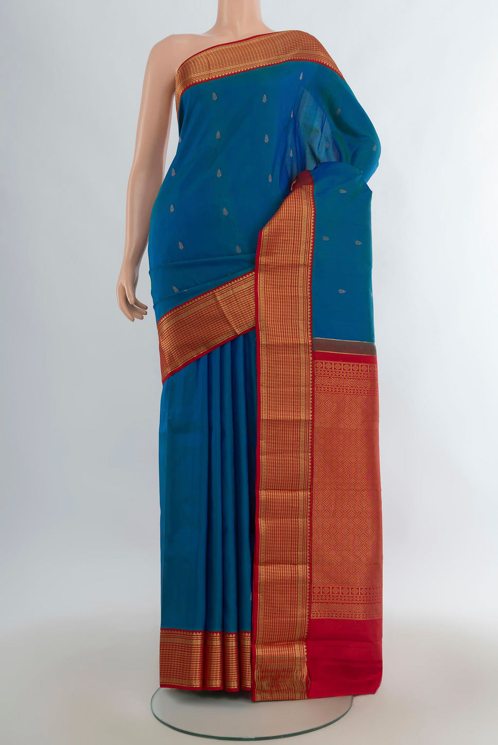 Pure Silk Peacock Blue Kanchipuram Saree with Zari Butta on the body and Zari Border.  displayed on a mannequin