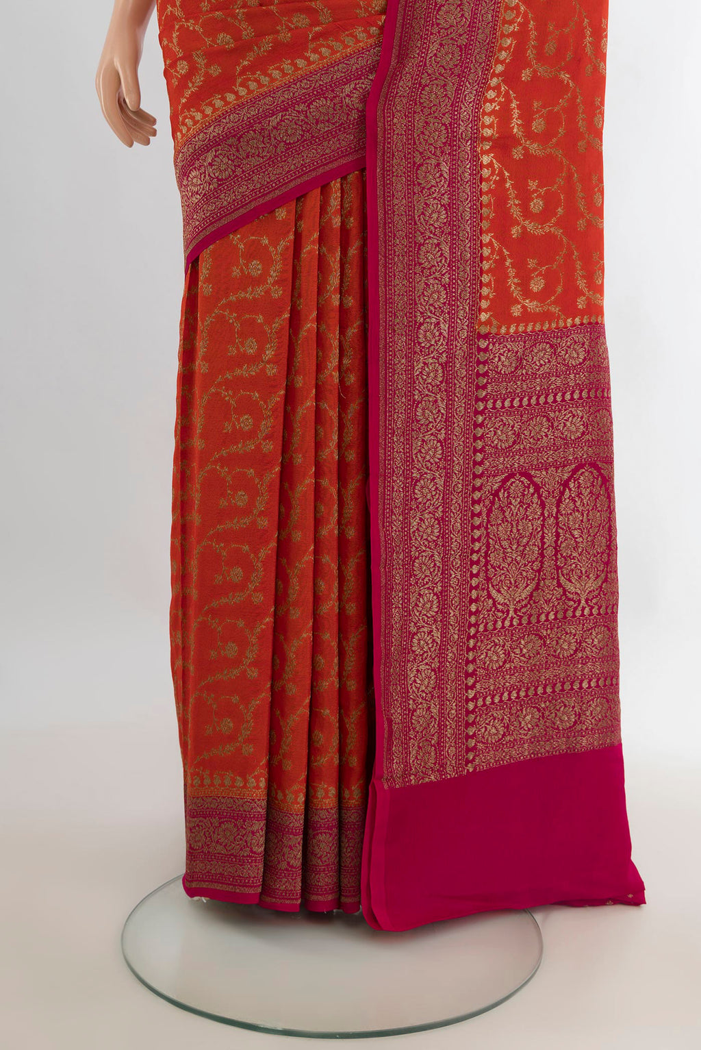 Pleats and pallu of Orange Banarasi Georgette Saree with Zari Brocade on the body and Zari Border. 