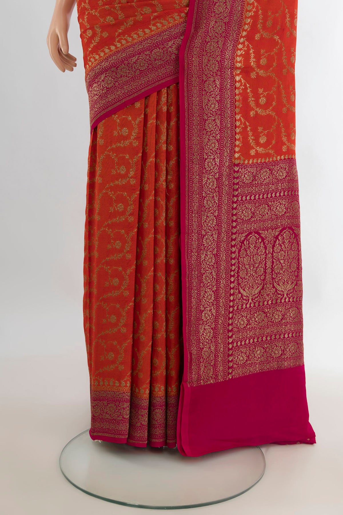 Pleats and pallu of Orange Banarasi Georgette Saree with Zari Brocade on the body and Zari Border. 