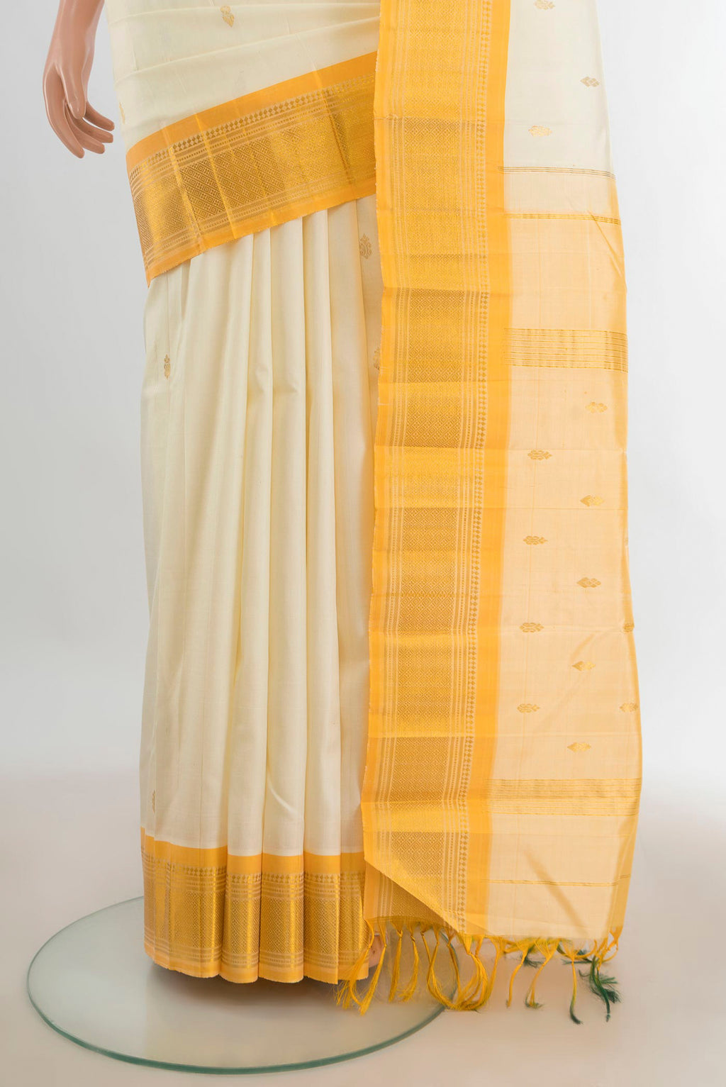 Pleats and pallu of Pure Silk Cream Kanjivaram Saree with Zari Butta on the body and Silk Border. 
