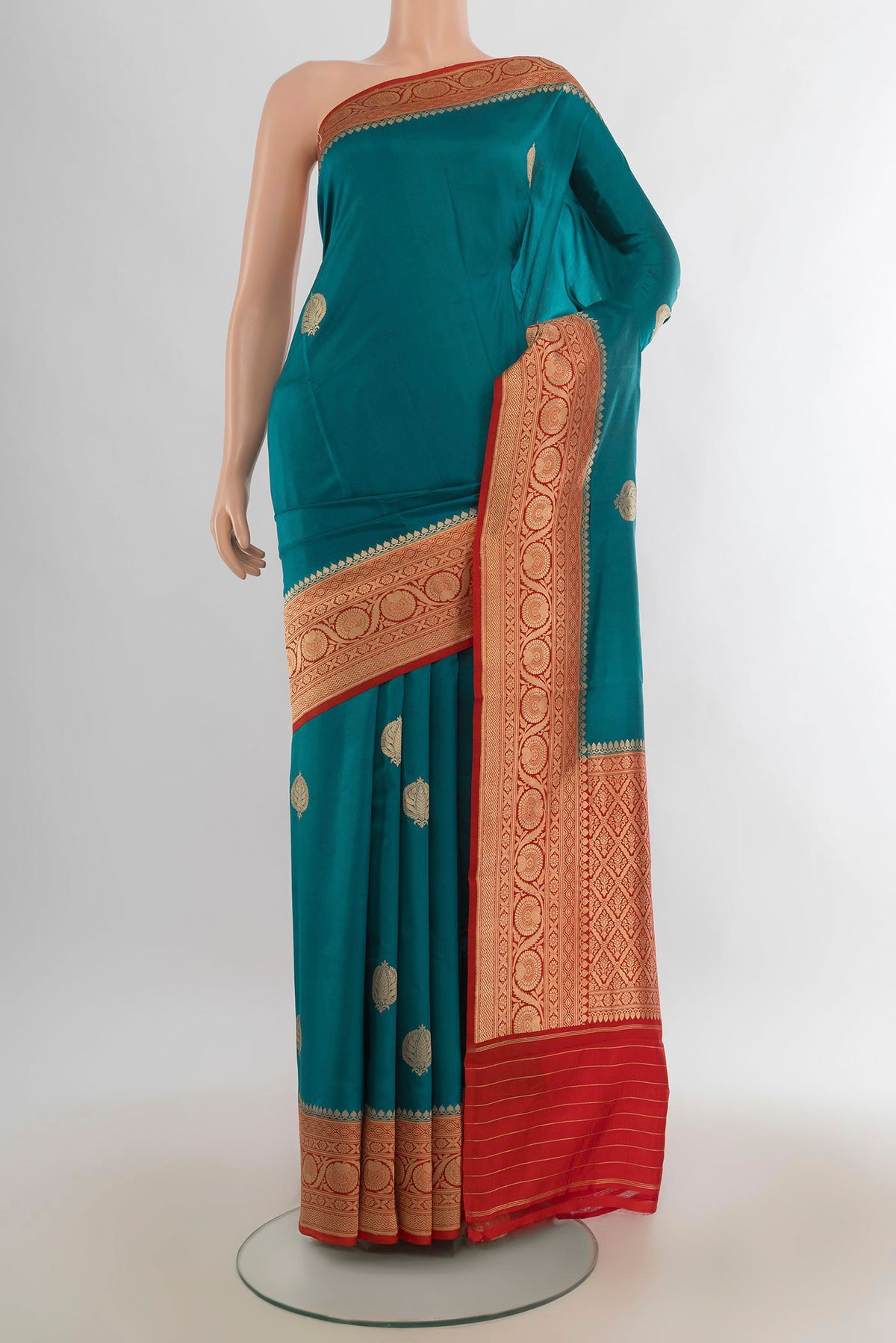 Pure Silk Teal Banarasi Katan Saree with Zari Butta on the body and Zari Border.  displayed on a mannequin