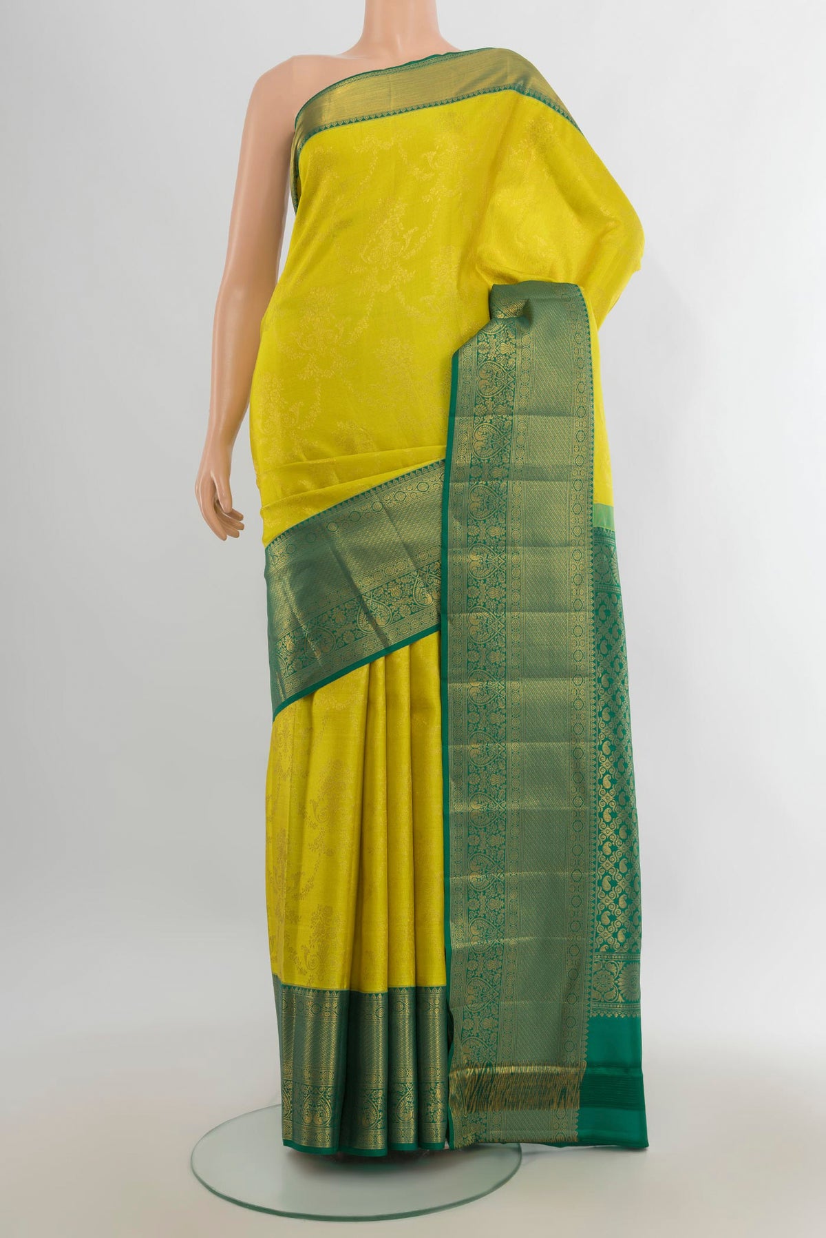 Pure Silk Light Green Kanjivaram Saree with Zari Butta on the body and Silk Border.  displayed on a mannequin