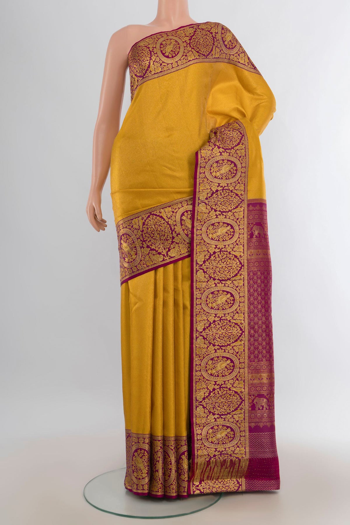 Pure Silk Yellow Kanjivaram Saree with Zari Butta on the body and Silk Border.  displayed on a mannequin