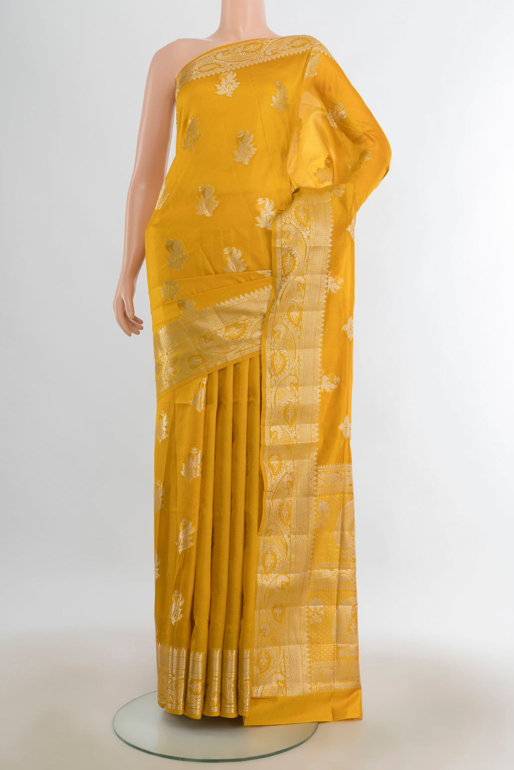 Pure Silk Mustard Banarasi Raw Saree with Zari Butta on the body and Silk Border.  displayed on a mannequin