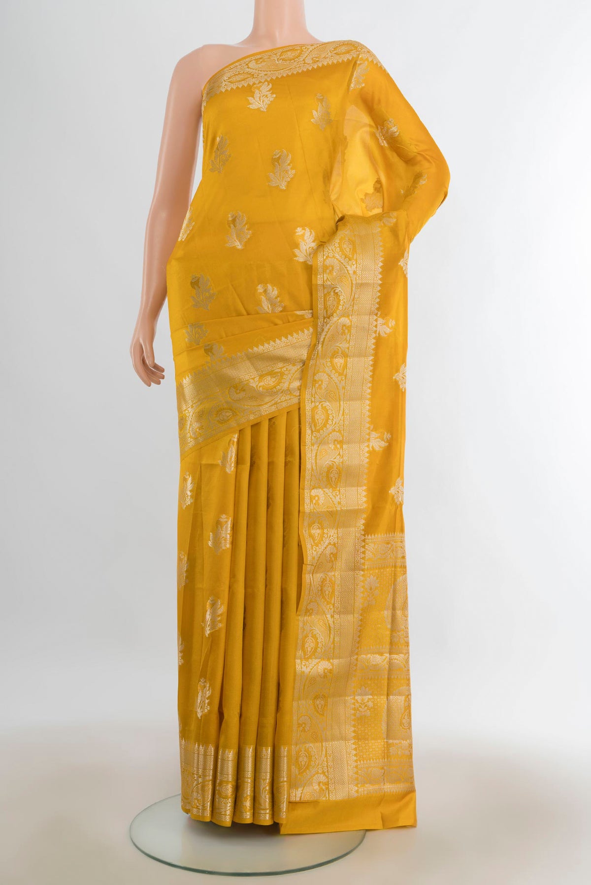 Pure Silk Mustard Banarasi Raw Saree with Zari Butta on the body and Silk Border.  displayed on a mannequin