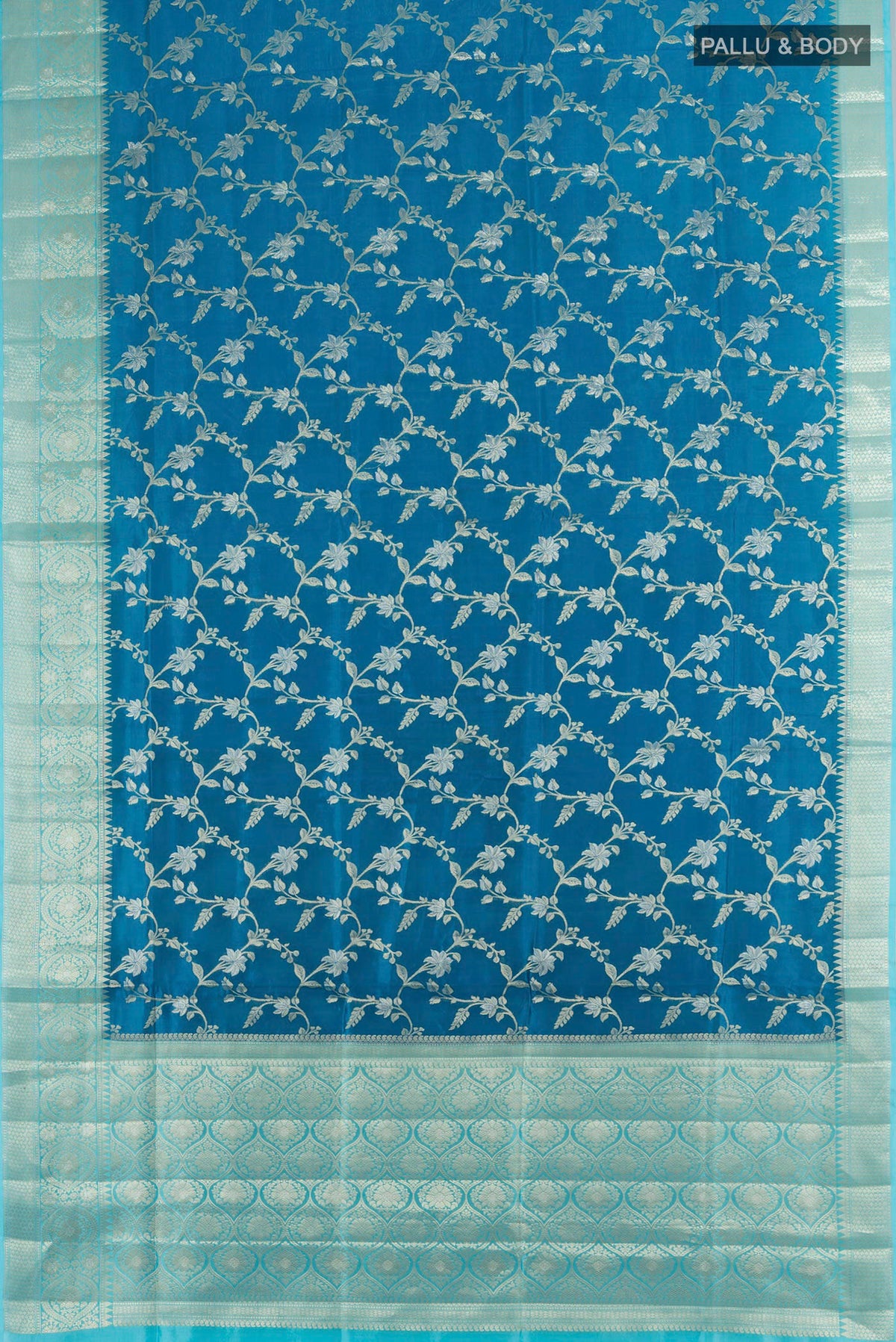 Flat view of Pure Silk Peacock Blue Banarasi Raw Saree with Zari Butta on the body and Silk Border. 