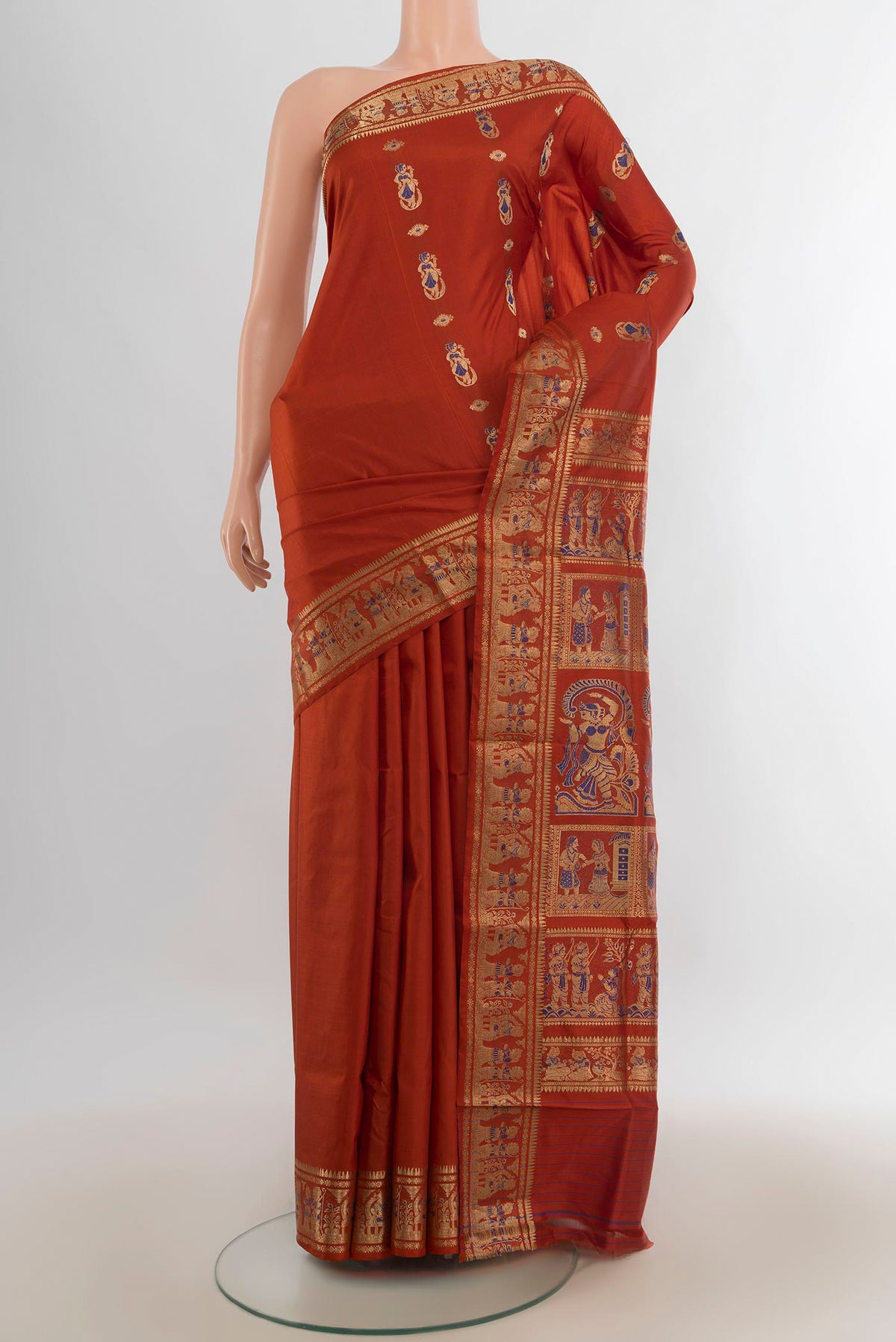 Pure Silk Rust Baluchari Saree with Zari And Thread Butta on the body and Zari Border.  displayed on a mannequin