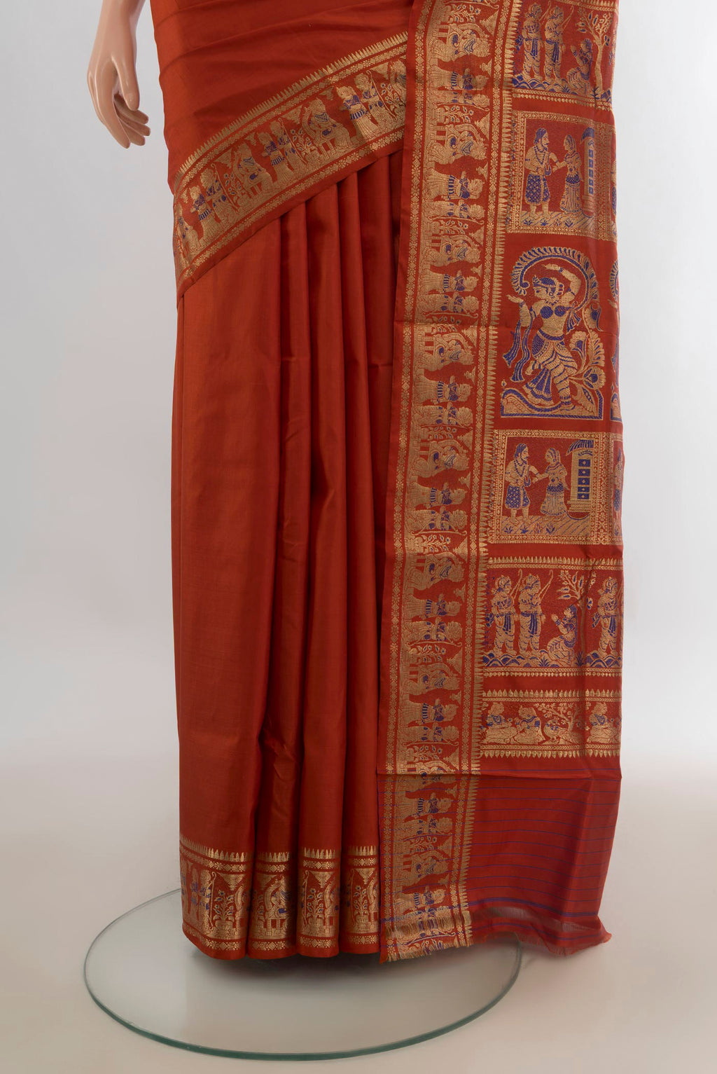 Pleats and pallu of Pure Silk Rust Baluchari Saree with Zari And Thread Butta on the body and Zari Border. 