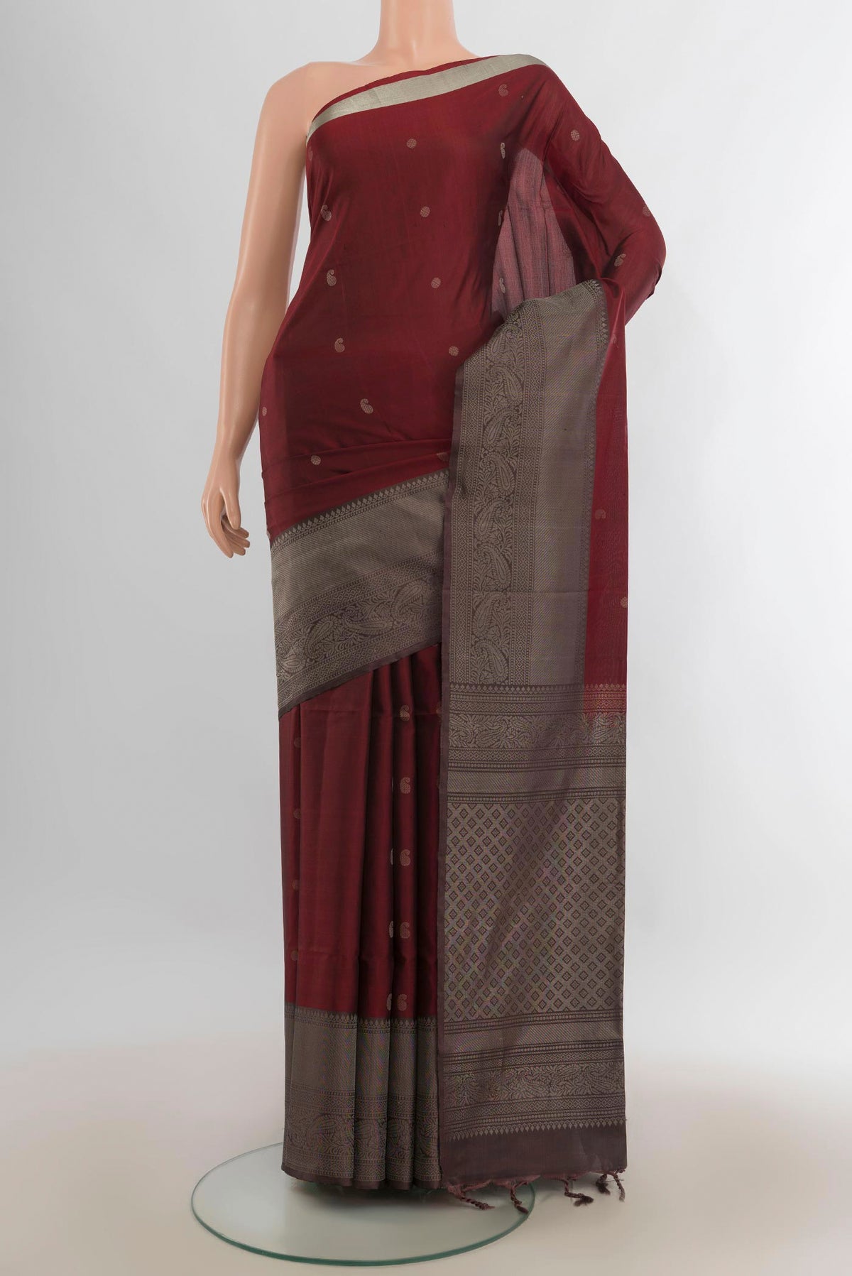 Pure Silk Rust Soft Saree with Zari Butta on the body and Fancy Border.  displayed on a mannequin