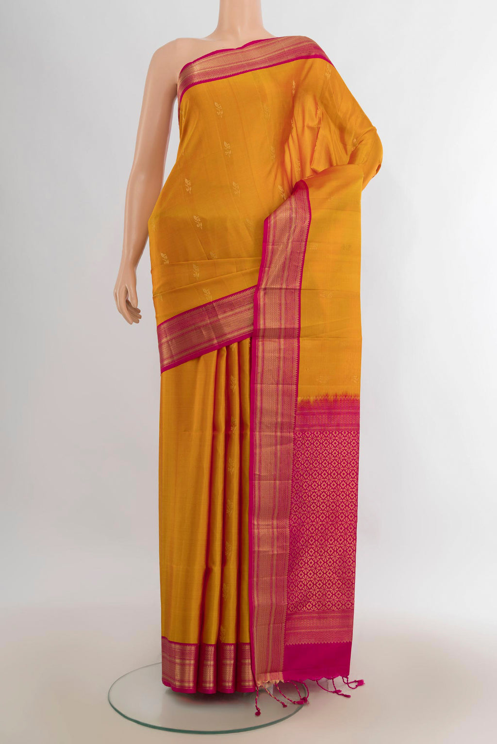 Pure Silk Mustard Soft Saree with Zari Butta on the body and Zari Border.  displayed on a mannequin