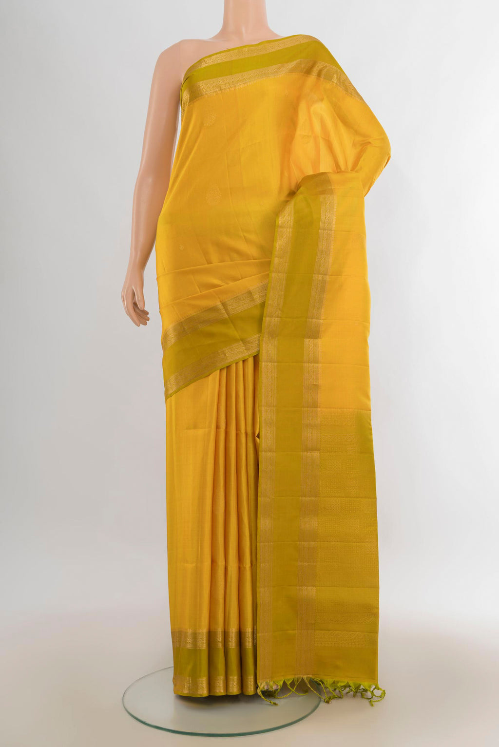 Pure Silk Mustard Soft Saree with Zari Butta on the body and Zari Border.  displayed on a mannequin