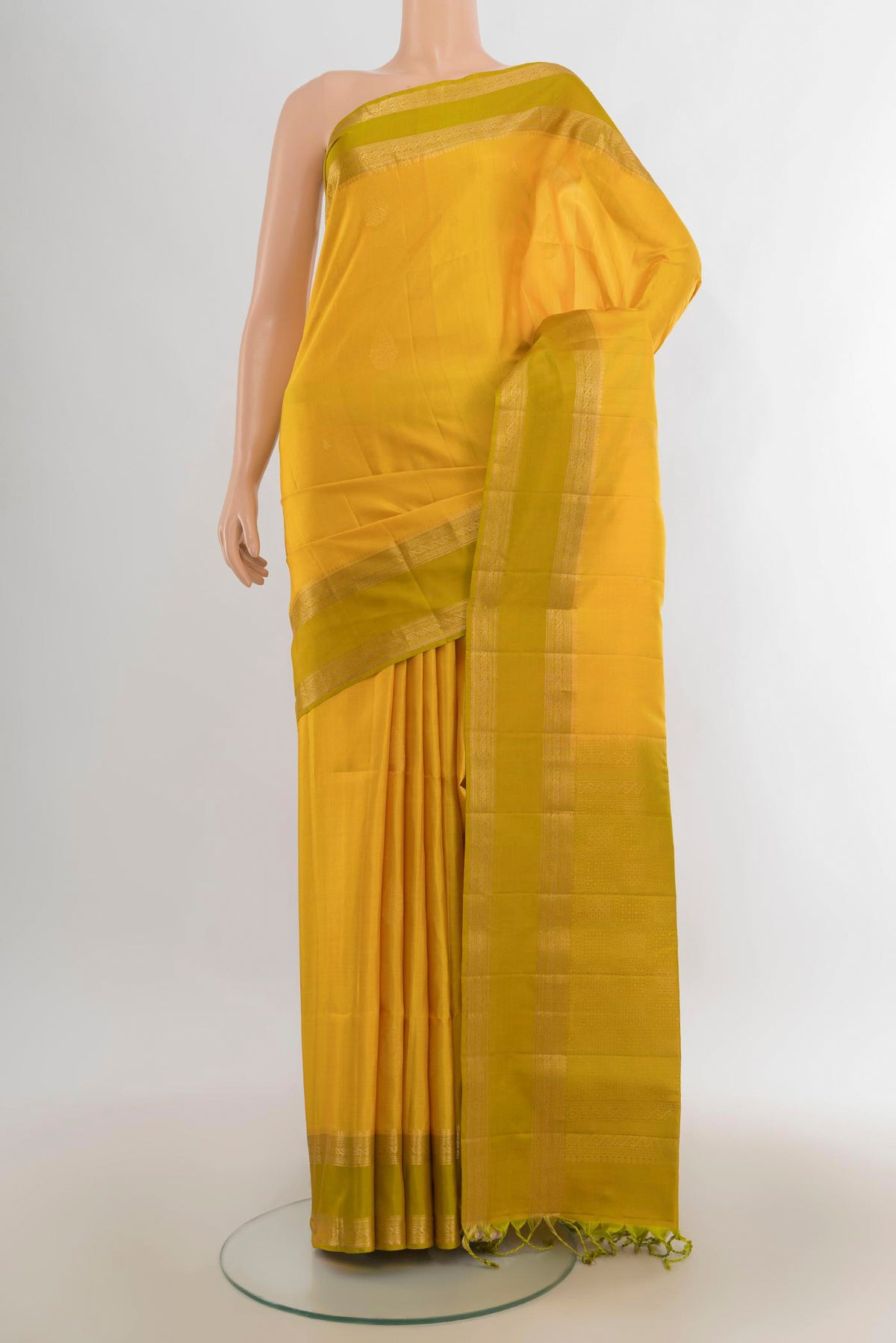 Pure Silk Mustard Soft Saree with Zari Butta on the body and Zari Border.  displayed on a mannequin