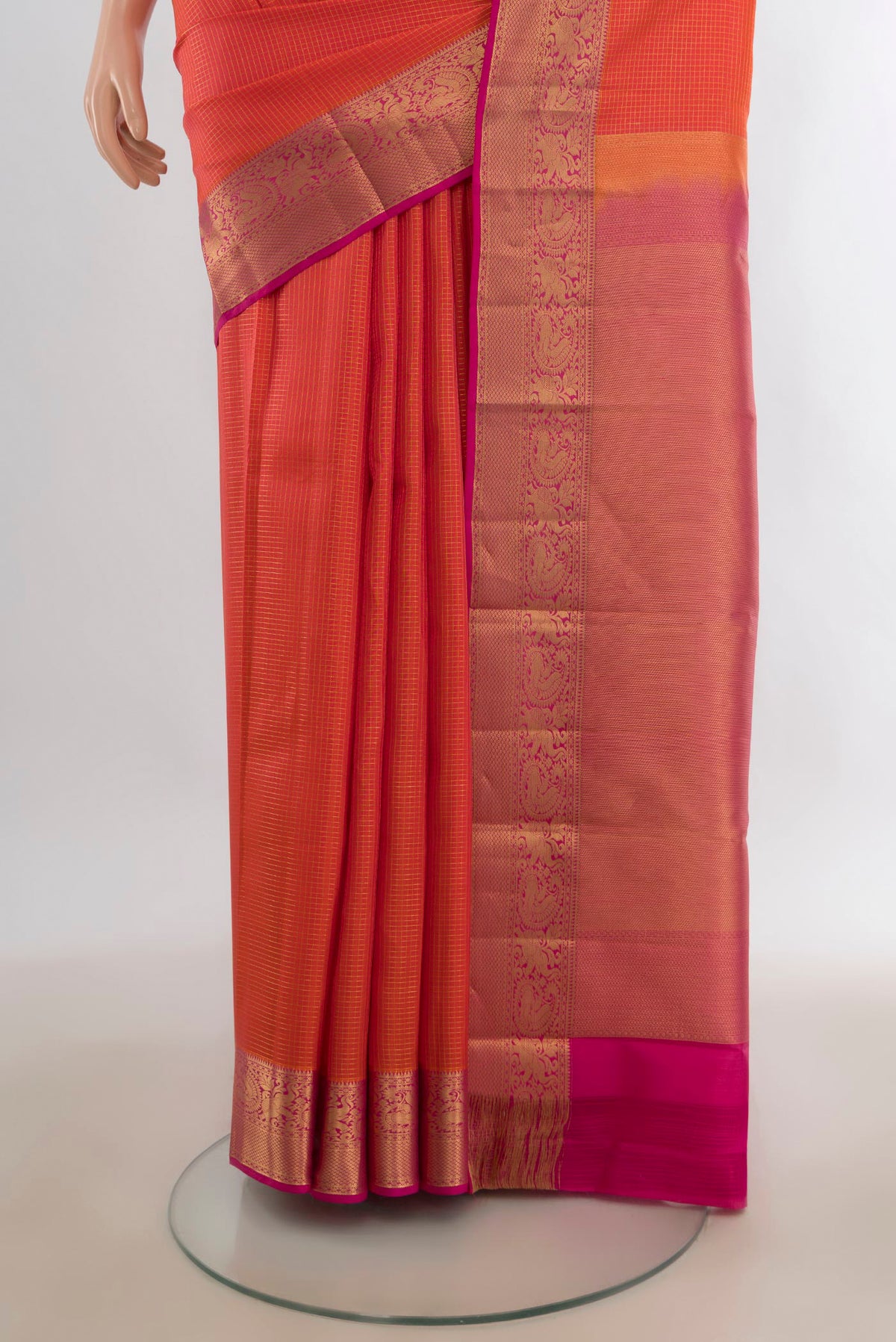 Pleats and pallu of Pure Silk Orange Kanchipuram Saree with Checked design on the body and Zari Border. 