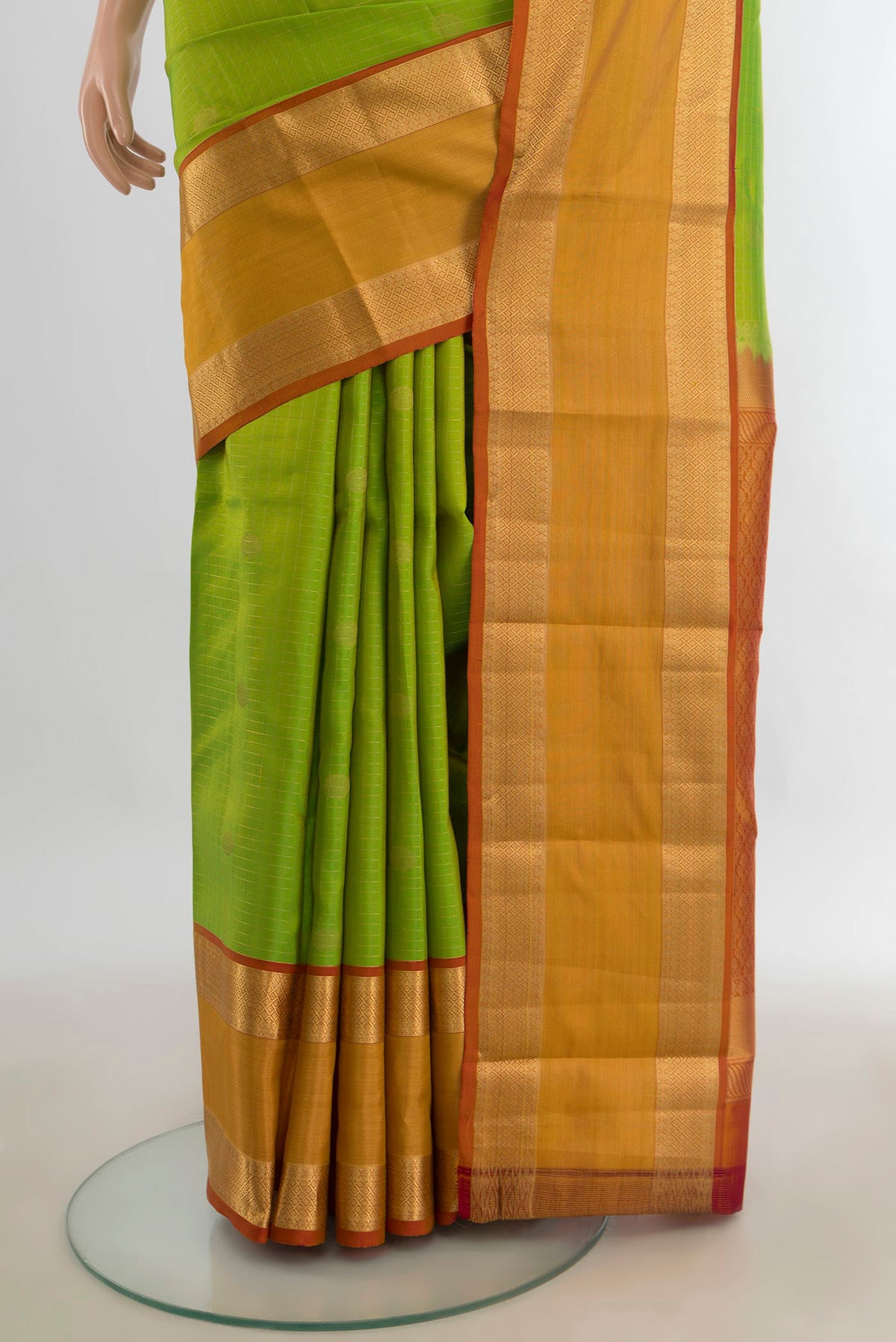 Pleats and pallu of Pure Silk Parrot Green Kanchipuram Saree with Zari Butta on the body and Silk Border. 
