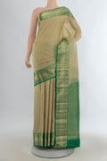 Pure Silk Beige Kanjivaram Saree with Zari Butta on the body and Zari Border.  displayed on a mannequin