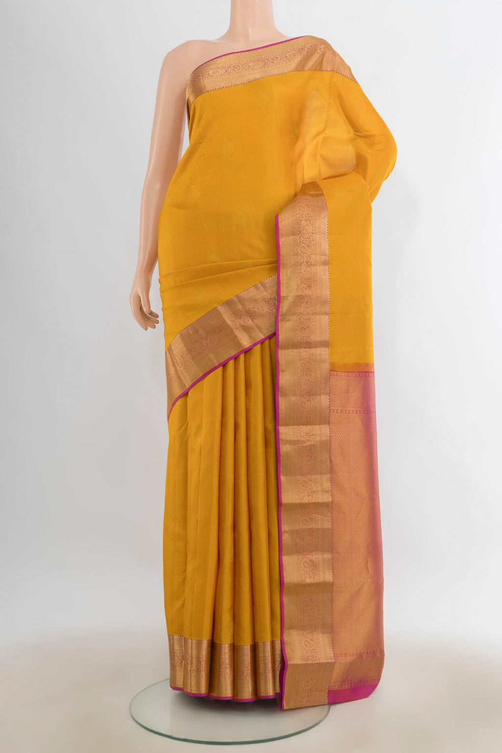 Pure Silk Mustard Kanjivaram Saree with Zari Butta on the body and Zari Border.  displayed on a mannequin