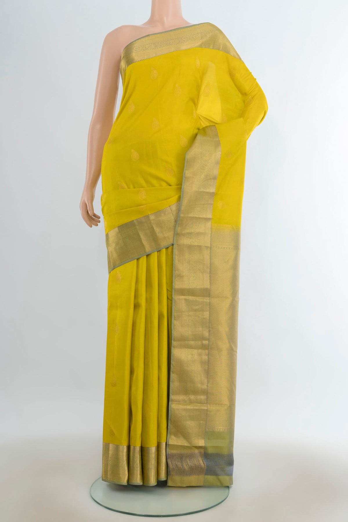 Pure Silk Light Green Kanjivaram Saree with Zari Butta on the body and Silk Border.  displayed on a mannequin