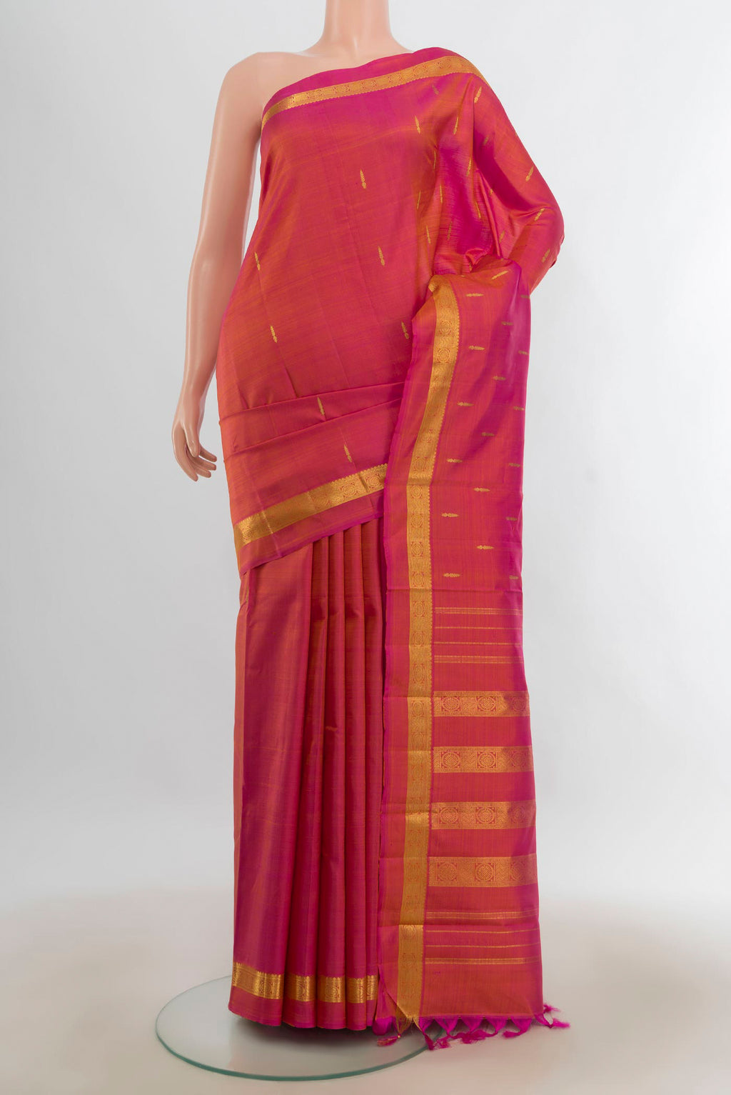 Pure Silk Pure Zari Peach Kanjivaram Saree with Zari Butta on the body and Silk Border.  displayed on a mannequin