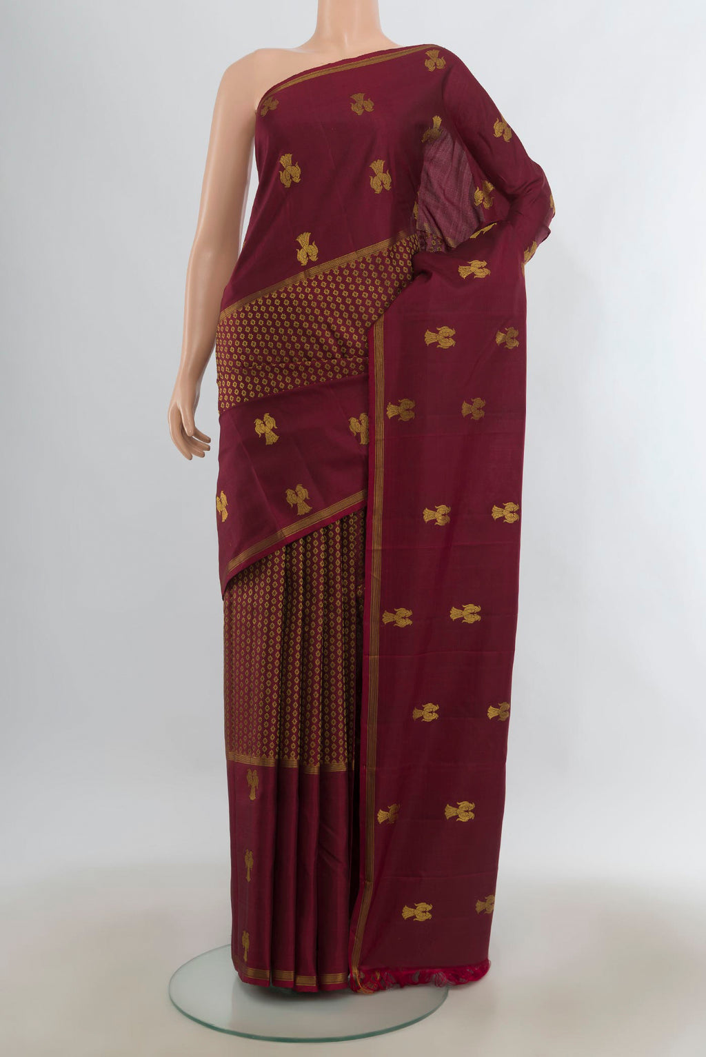 Pure Silk Maroon Kanjivaram Saree with Zari Butta on the body and Plain Border.  displayed on a mannequin