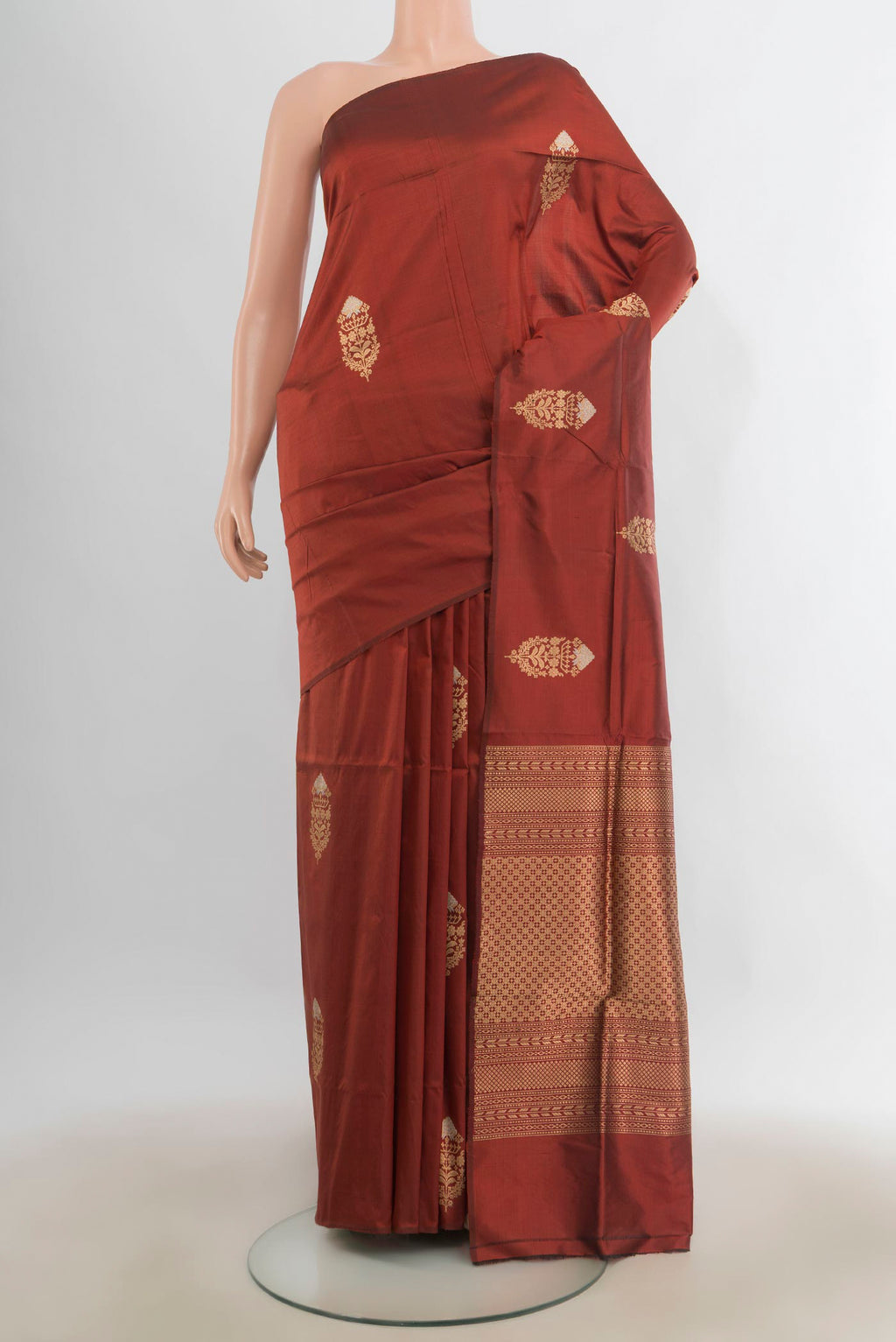 Pure Silk Rust Banarasi Katan Saree with Zari Butta on the body and Without Border.  displayed on a mannequin