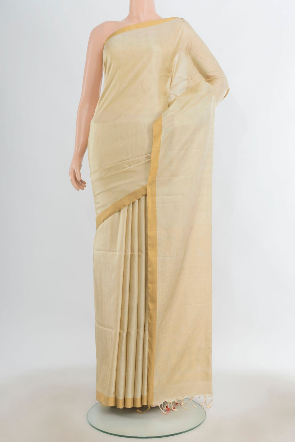 Pure Silk Golden Soft Saree with Zari Butta on the body and Silk Border.  displayed on a mannequin