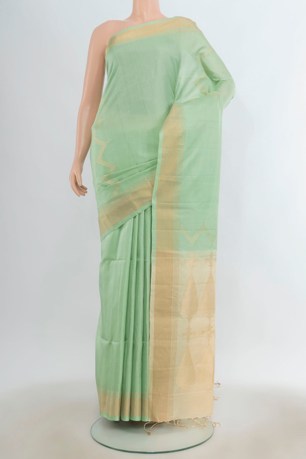 Pure Silk Pista Green Soft Saree with Zari Butta on the body and Silk Border.  displayed on a mannequin