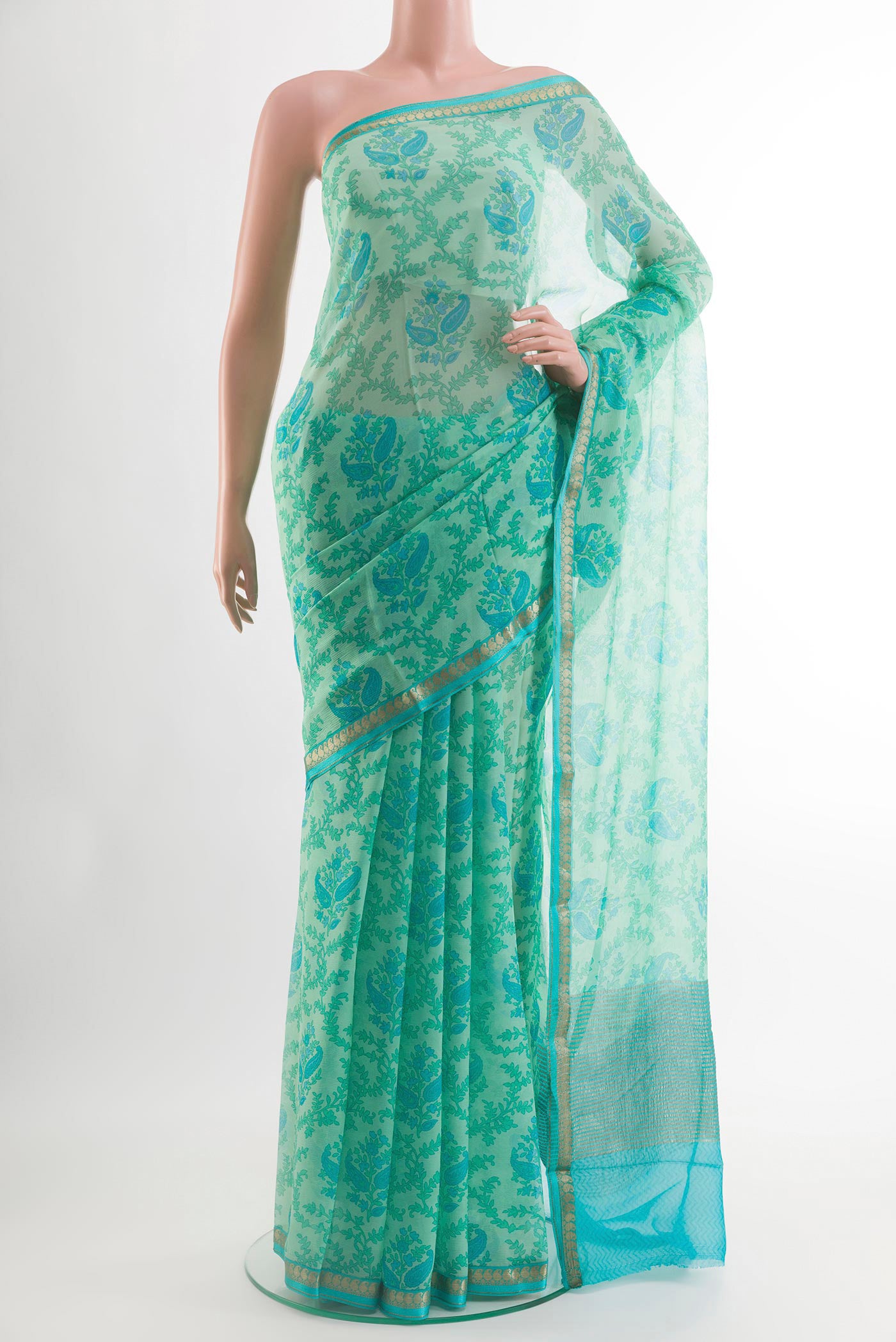 Green Chiffon Saree with Printed design on the body and Zari Border.  displayed on a mannequin