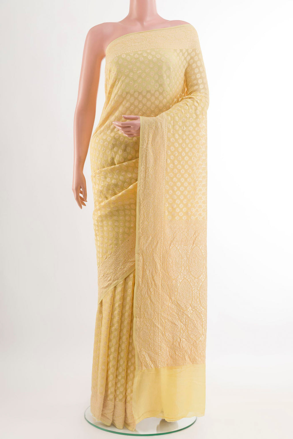 Yellow Banarasi Georgette Saree with Zari Butta on the body and Zari Border.  displayed on a mannequin