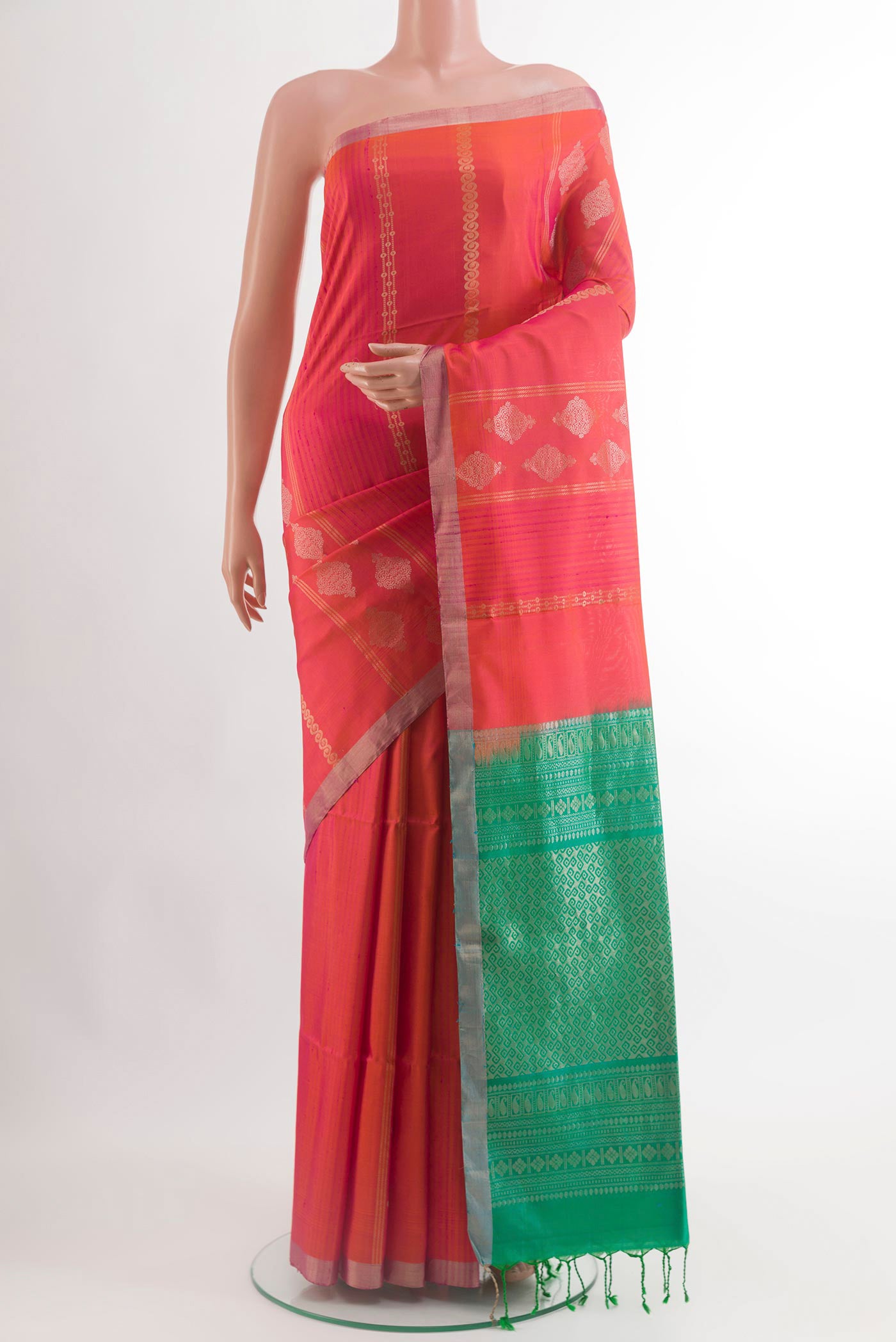 Brick Orange Soft Silk Saree with Zari Butta on the body and Zari Border.  displayed on a mannequin
