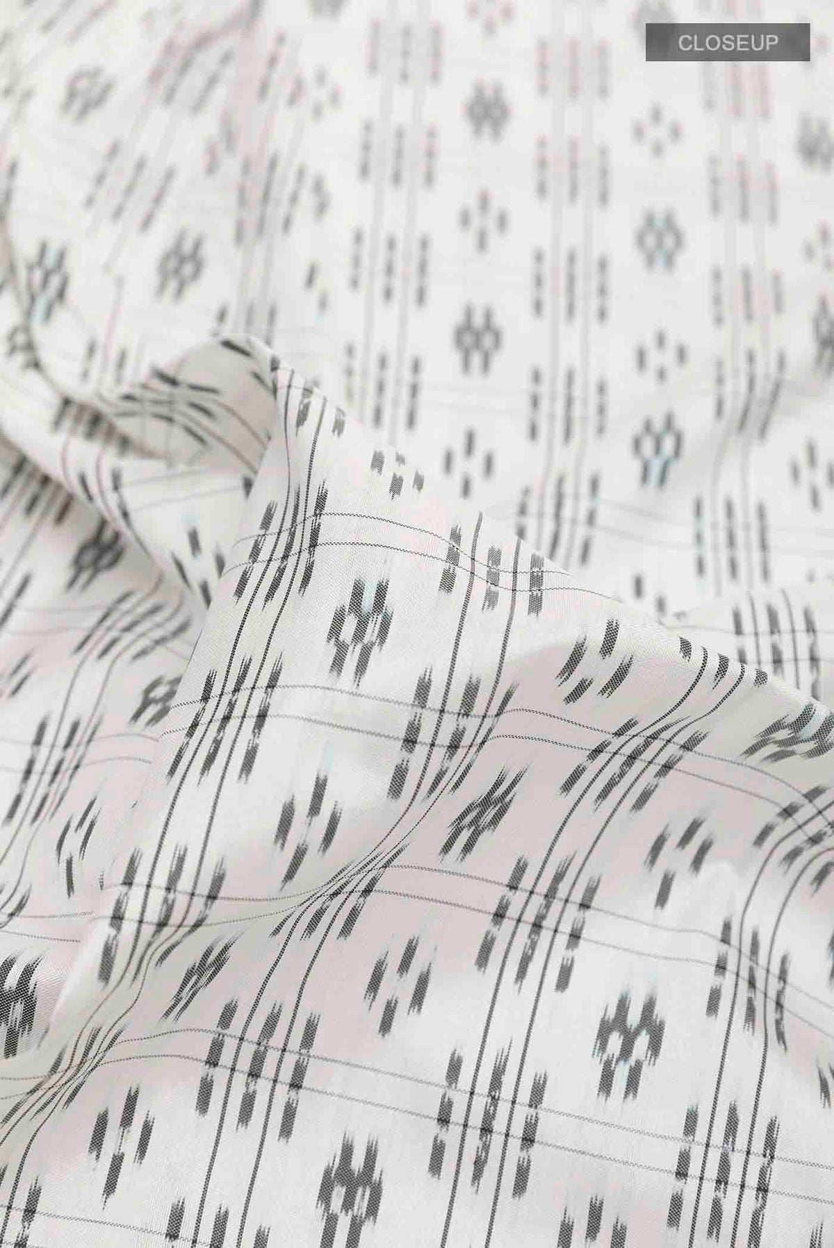 Close up of White Pochampally Silk Saree with Pure Ikat on the body and Plain Border displaying folds