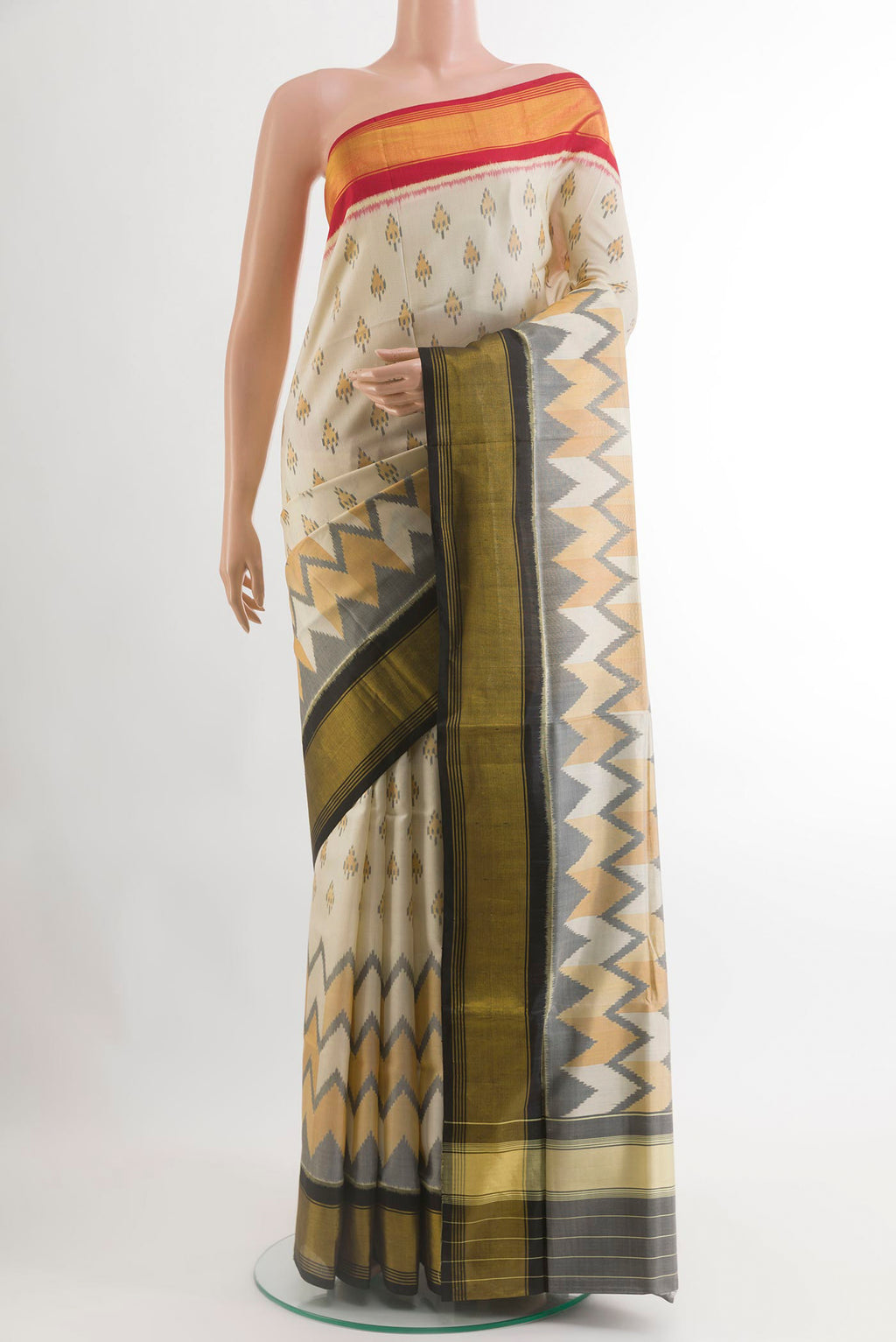 Cream Rajkot Patola Silk Saree with Pure Ikat on the body and Ganga Jamuna Border.  displayed on a mannequin