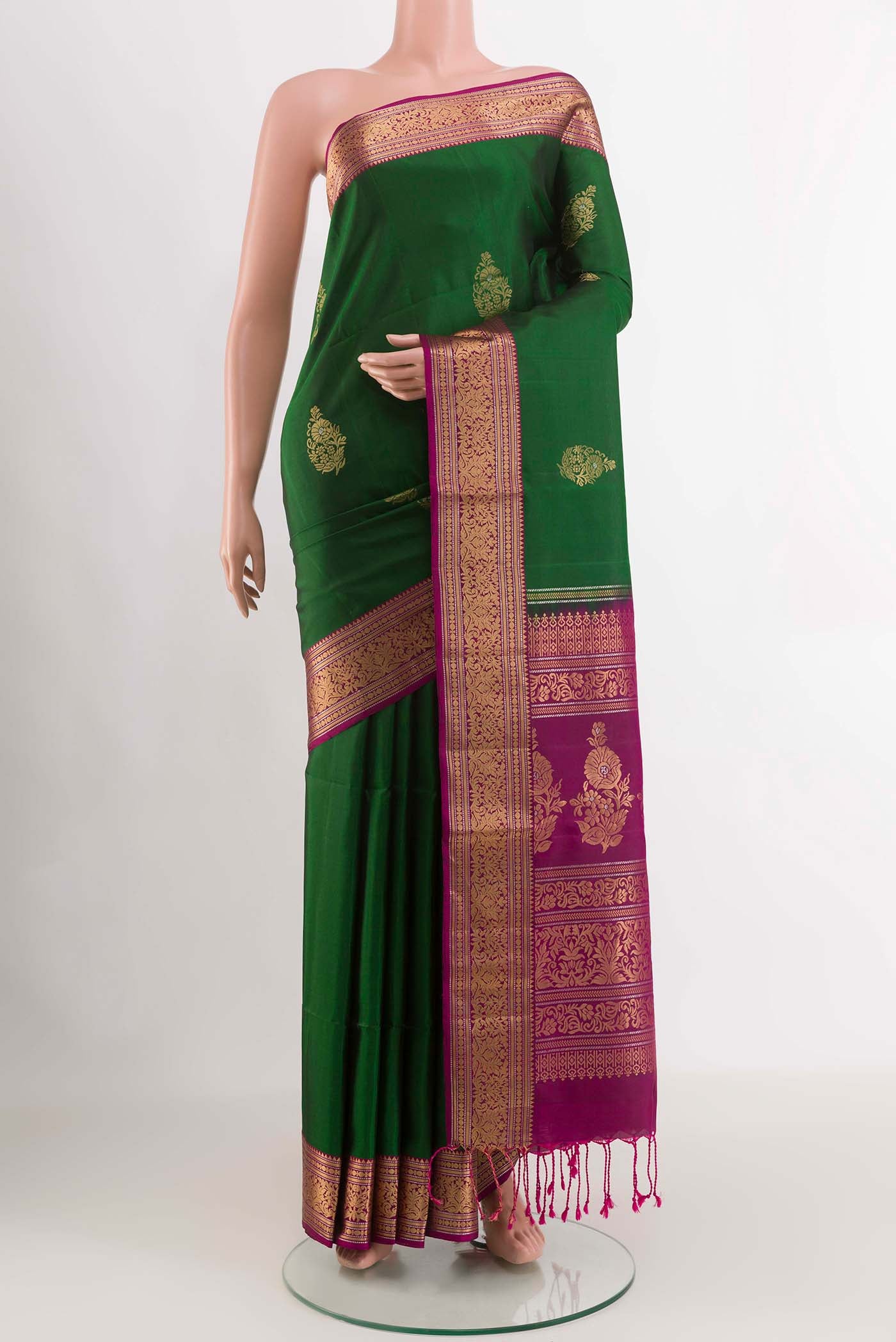 Green Soft Silk Saree with Zari Butta on the body and Zari Border displayed on a mannequin