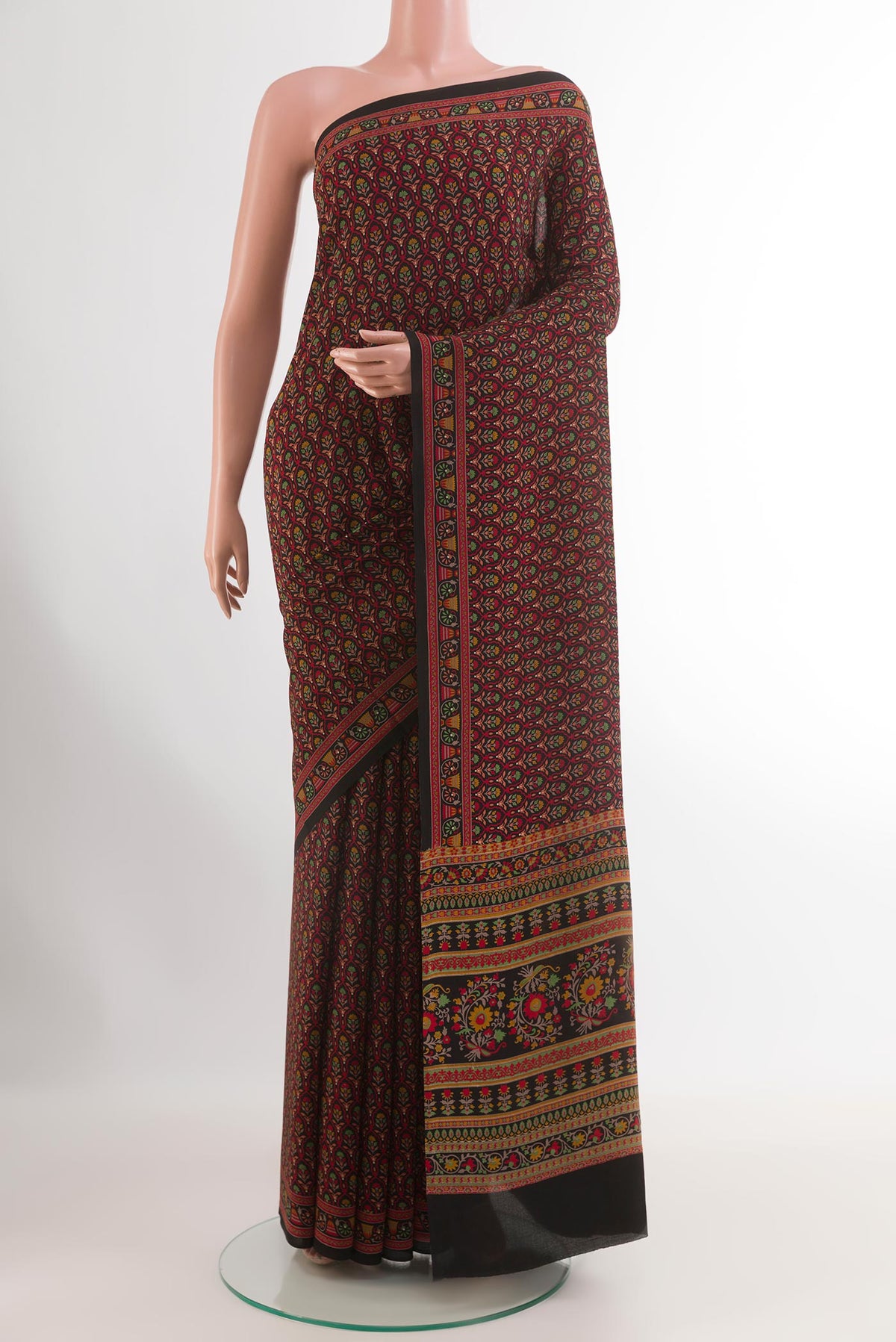 Red Crepe Saree with Printed design on the body and Printed Border.  displayed on a mannequin