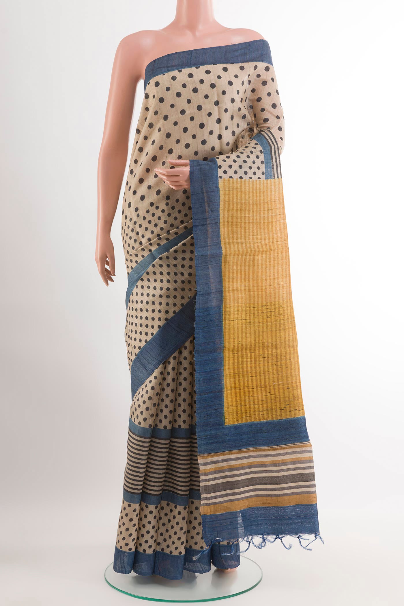 Off White Tussar Saree with Printed design on the body and Zari Border.  displayed on a mannequin