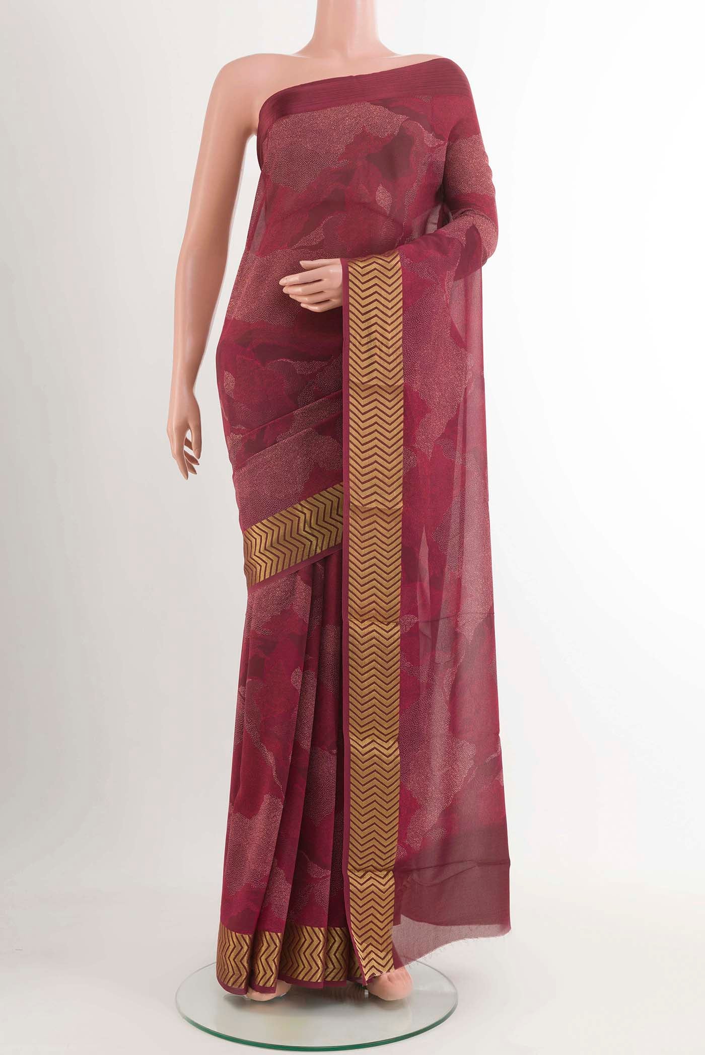 Maroon Crepe Saree With Printed design on the body and Zari Border displayed on a mannequin