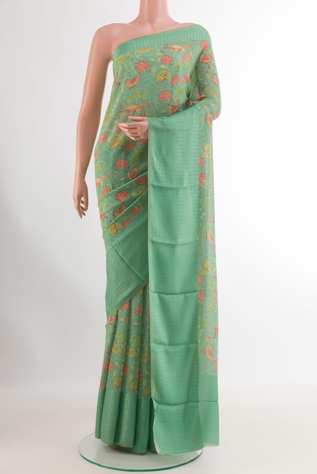 Green Crepe Saree with Printed design on the body and Printed Border.  displayed on a mannequin